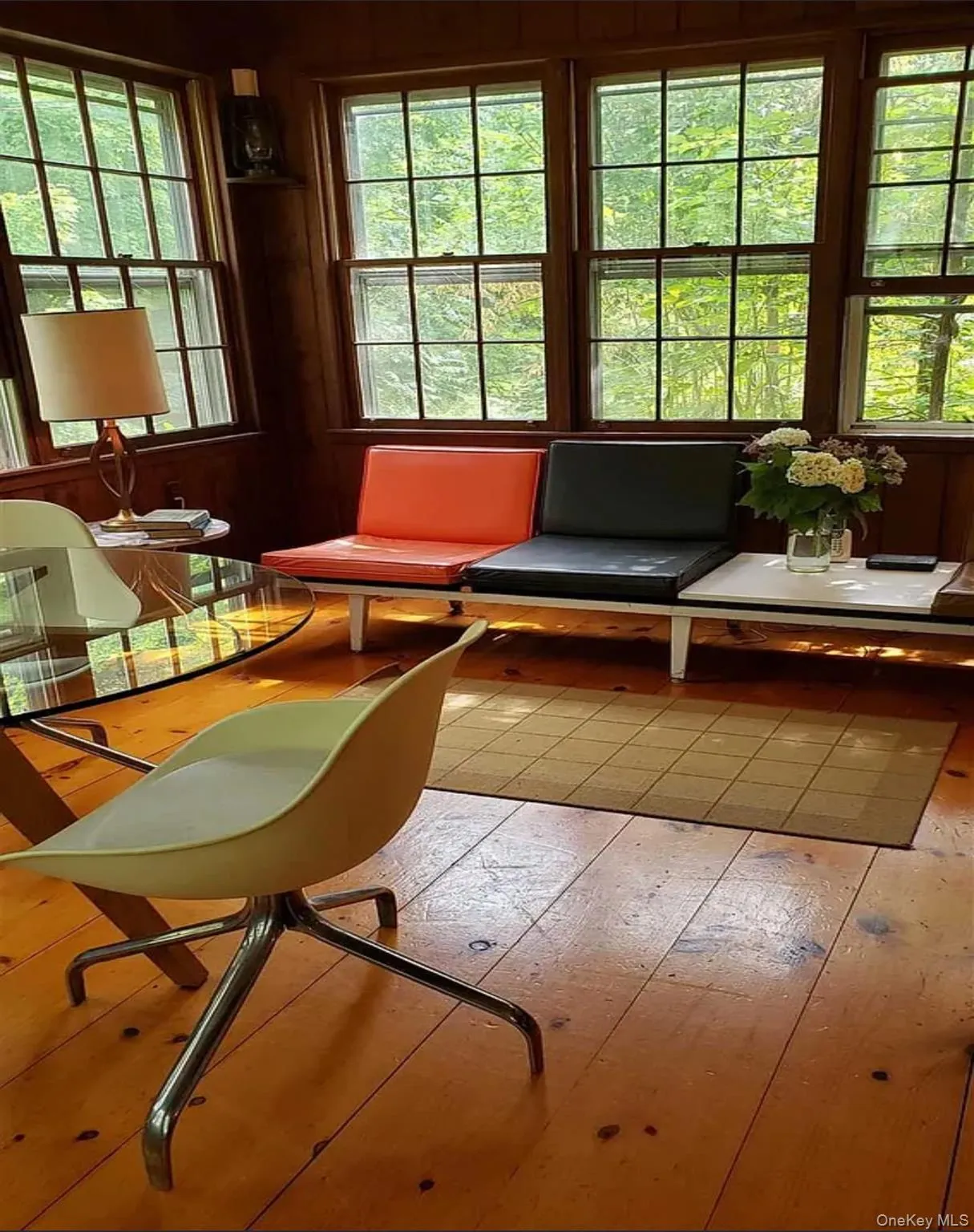 Living area with wood floors, wall of windows overlooking grounds and light wood-style floors Living area with wood floors, wall of windows overlooking grounds and light wood-style floors