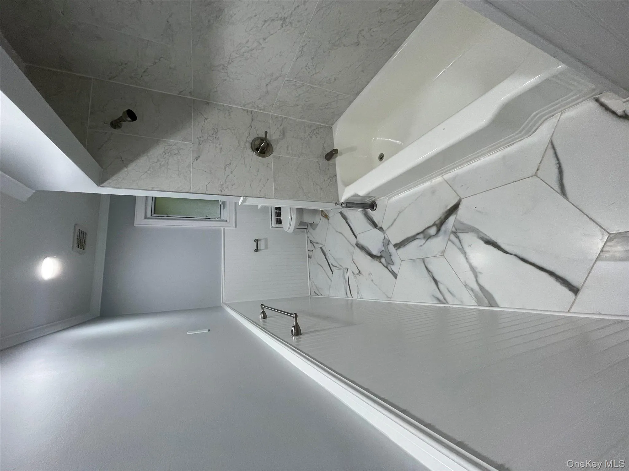 Full bathroom with a wainscoted wall, marble look tiles, bathing tub / shower combination, crown molding, and recessed lighting Full bathroom with a wainscoted wall, marble look tiles, bathing tub / shower combination, crown molding, and recessed lighting