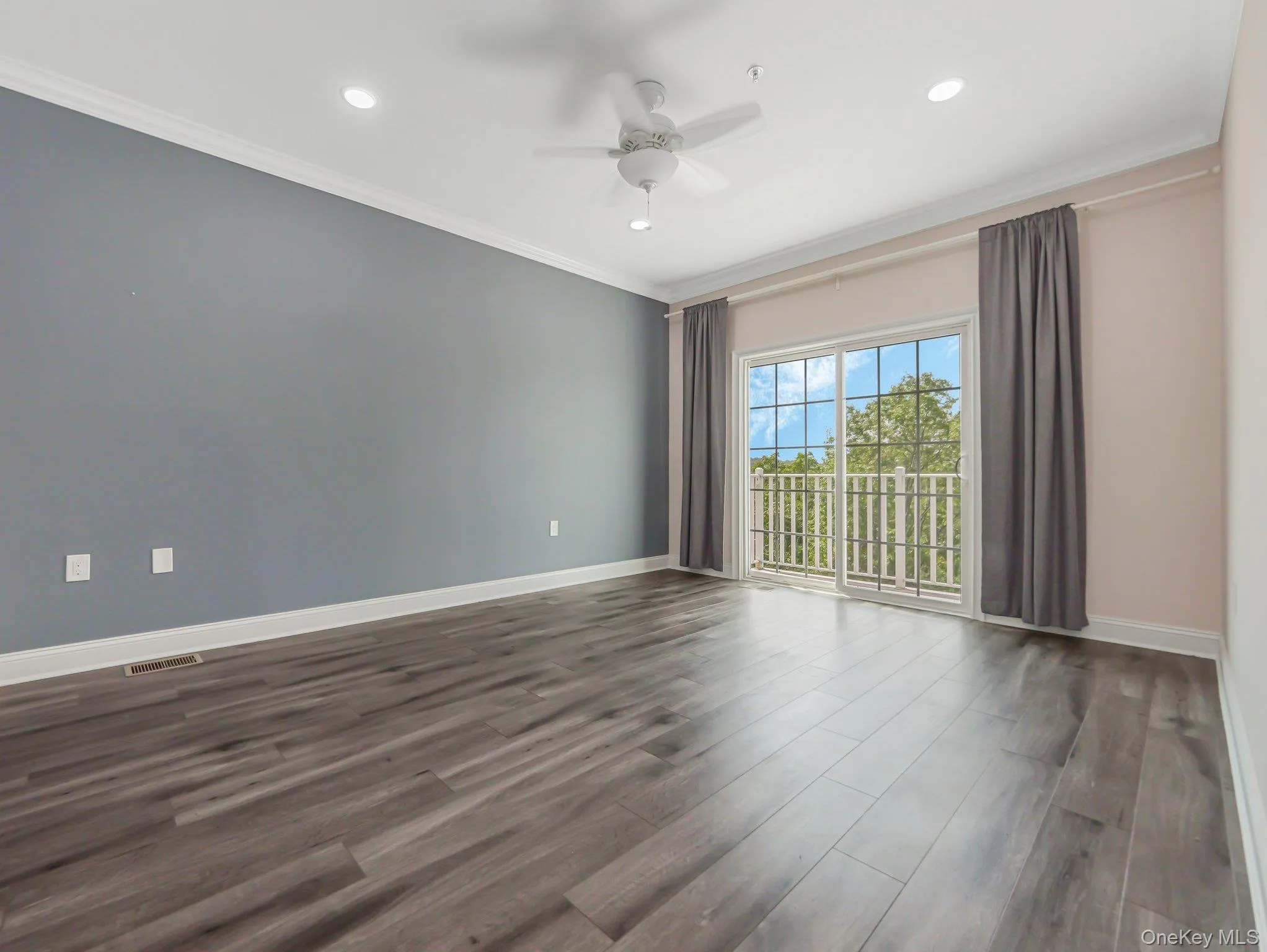 Empty room with dark wood-type flooring, ornamental molding, ceiling fan, and recessed lighting Empty room with dark wood-type flooring, ornamental molding, ceiling fan, and recessed lighting