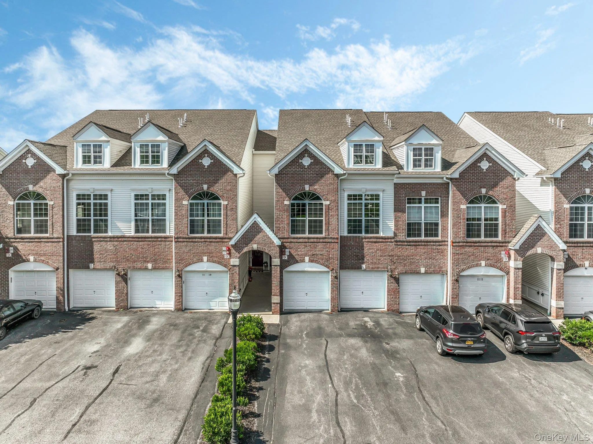 View of front facade with driveway, brick siding, and a garage View of front facade with driveway, brick siding, and a garage