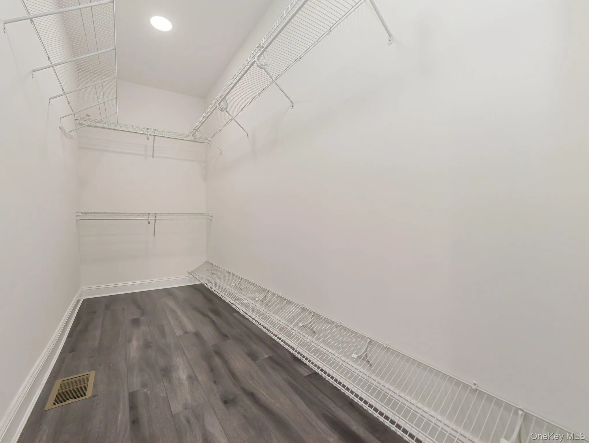 Walk in closet with dark wood-style flooring Walk in closet with dark wood-style flooring