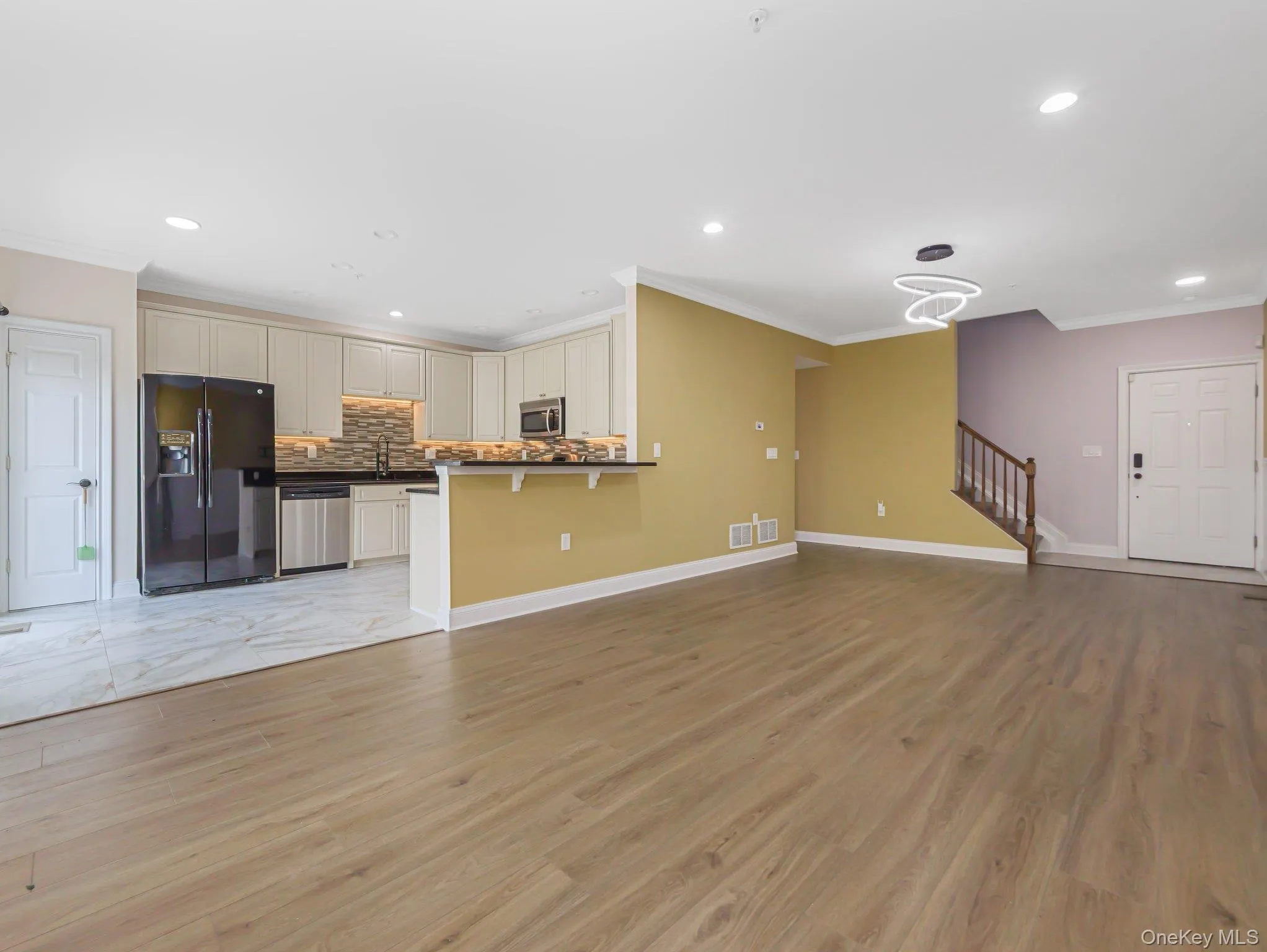 Unfurnished living room with ornamental molding, light wood finished floors, and recessed lighting Unfurnished living room with ornamental molding, light wood finished floors, and recessed lighting