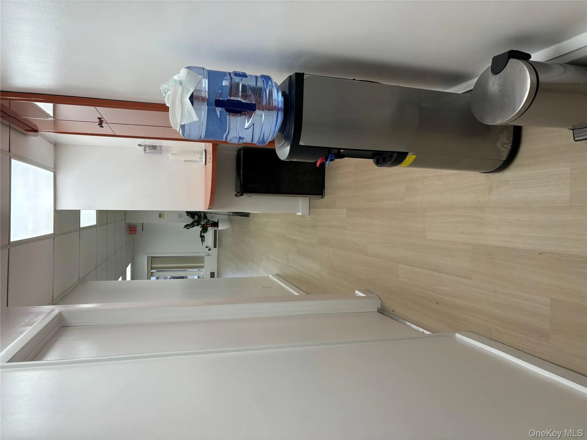 Corridor featuring a drop ceiling and light wood finished floors Corridor featuring a drop ceiling and light wood finished floors