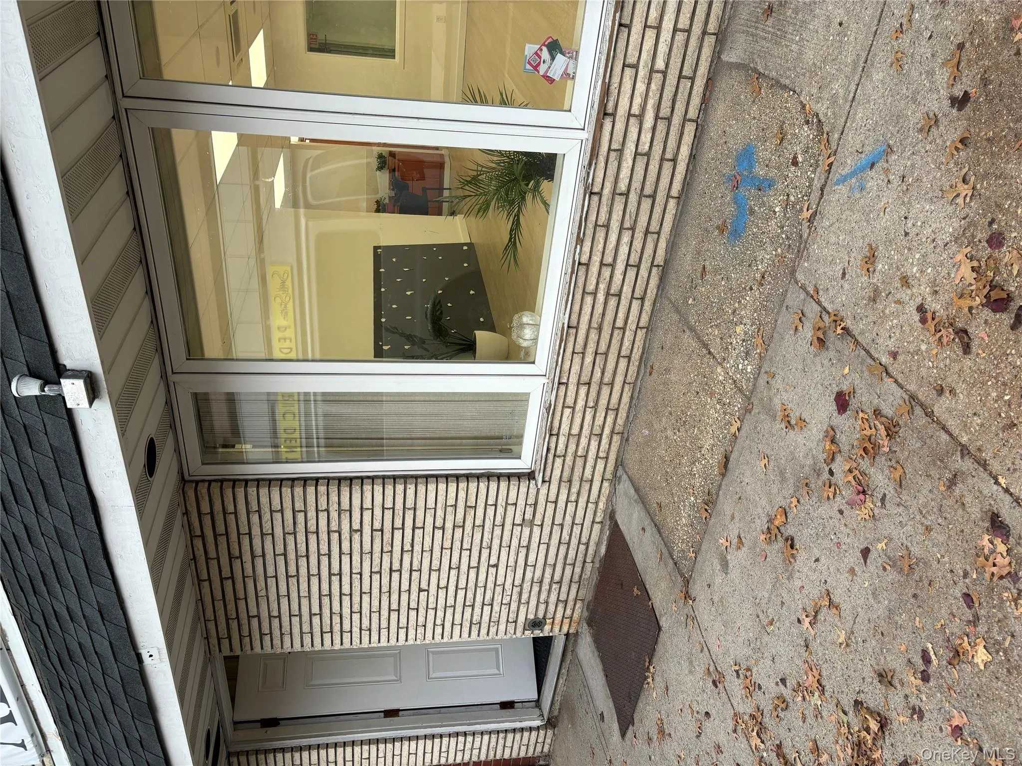 Property entrance featuring a shingled roof and brick siding Property entrance featuring a shingled roof and brick siding