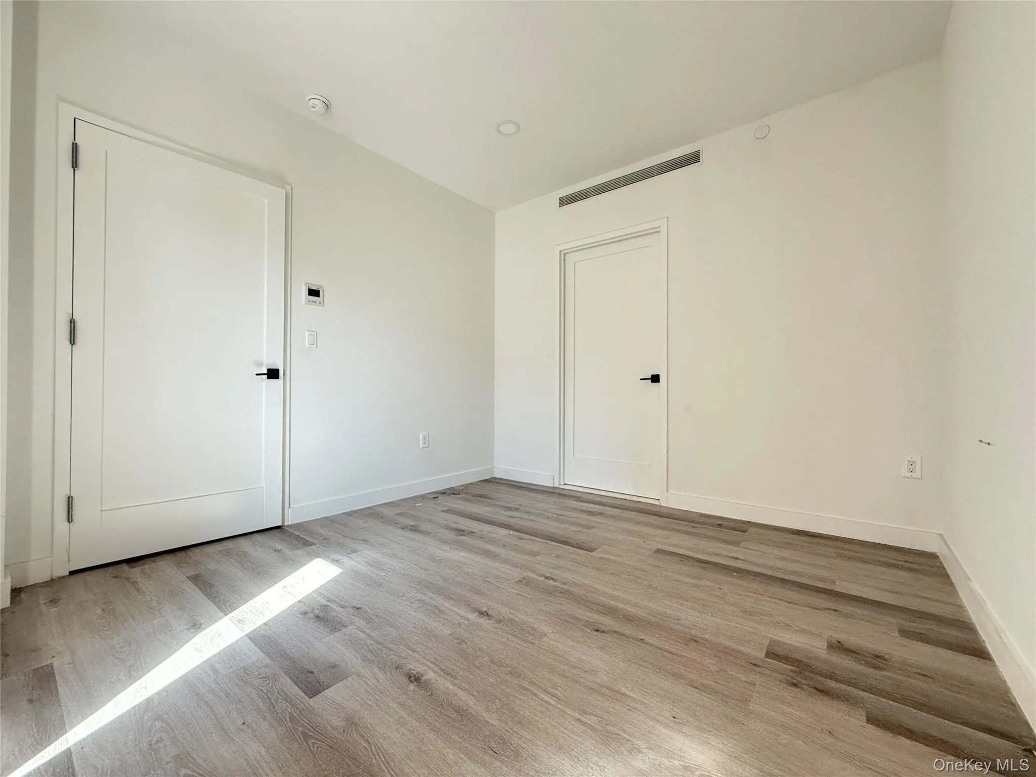 Unfurnished room featuring light wood finished floors and recessed lighting Unfurnished room featuring light wood finished floors and recessed lighting