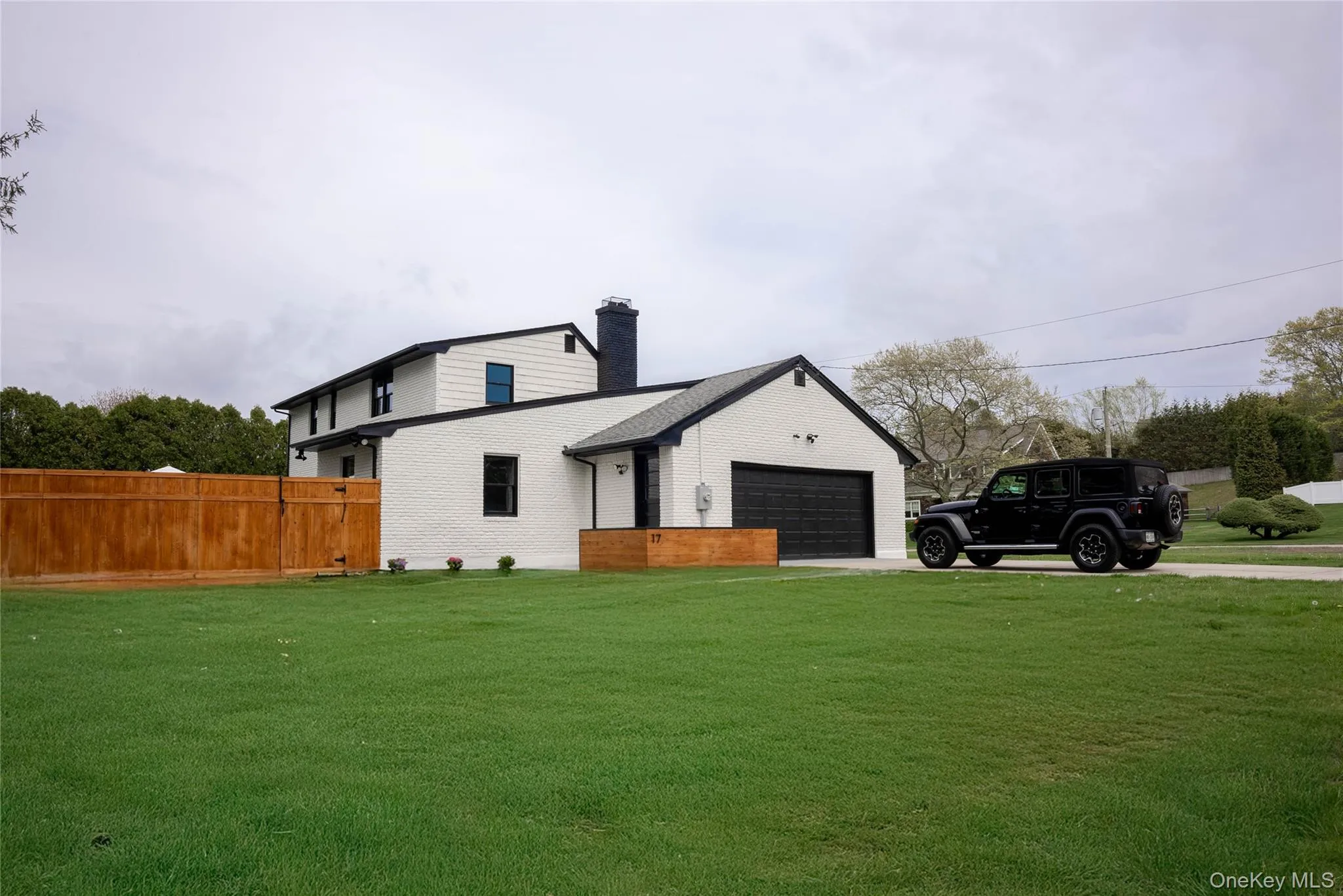 View of home's exterior with a chimney, driveway, and brick siding View of home's exterior with a chimney, driveway, and brick siding