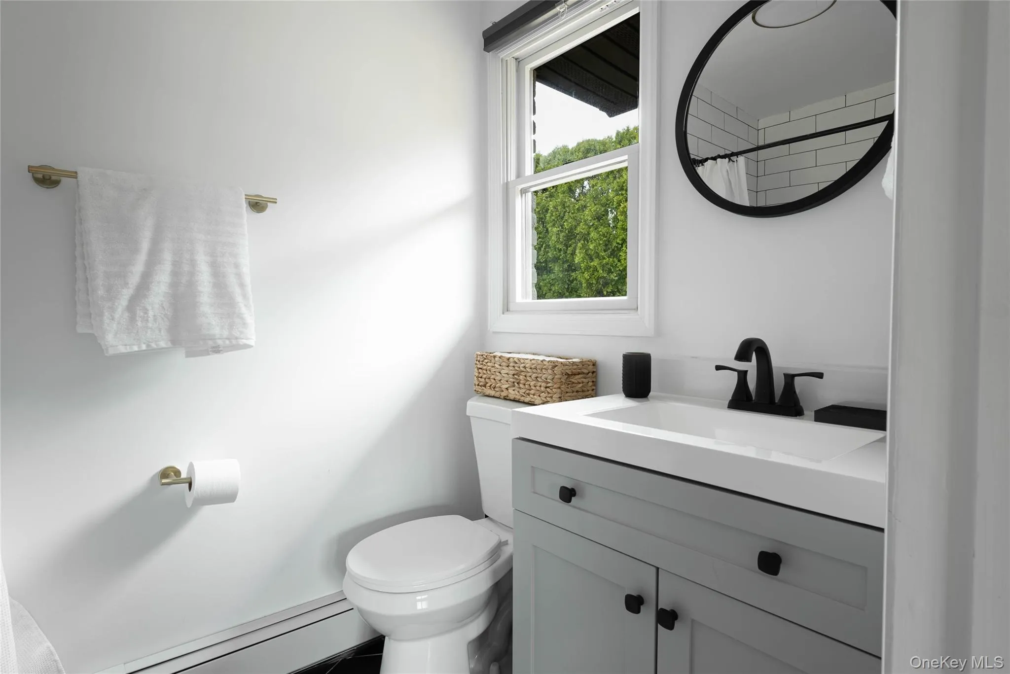 Full bathroom featuring vanity, a shower with curtain, and a baseboard radiator Full bathroom featuring vanity, a shower with curtain, and a baseboard radiator