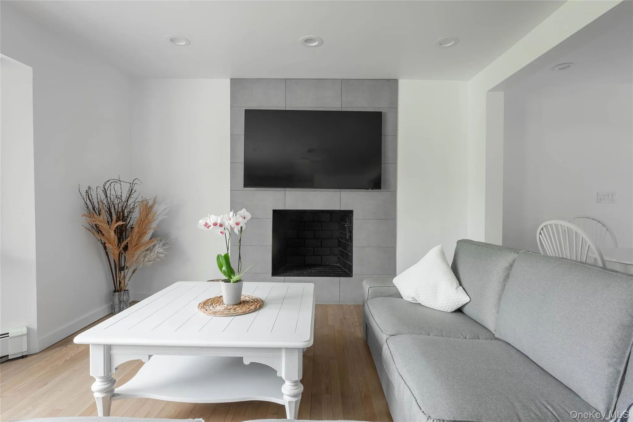 Living area featuring a tile fireplace, wood finished floors, and recessed lighting Living area featuring a tile fireplace, wood finished floors, and recessed lighting