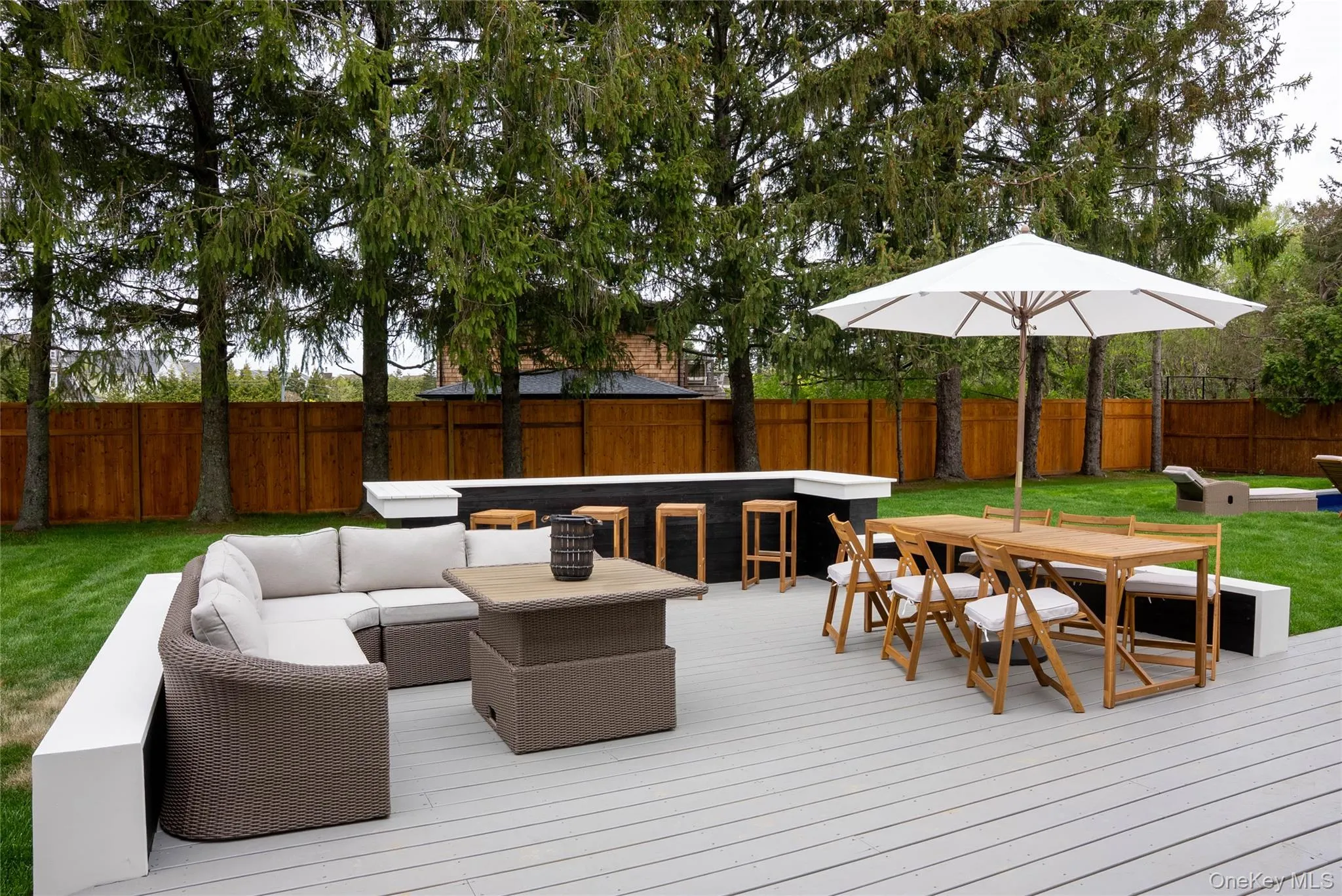 Wooden terrace featuring outdoor dining space, an outdoor hangout area, and a fenced backyard Wooden terrace featuring outdoor dining space, an outdoor hangout area, and a fenced backyard