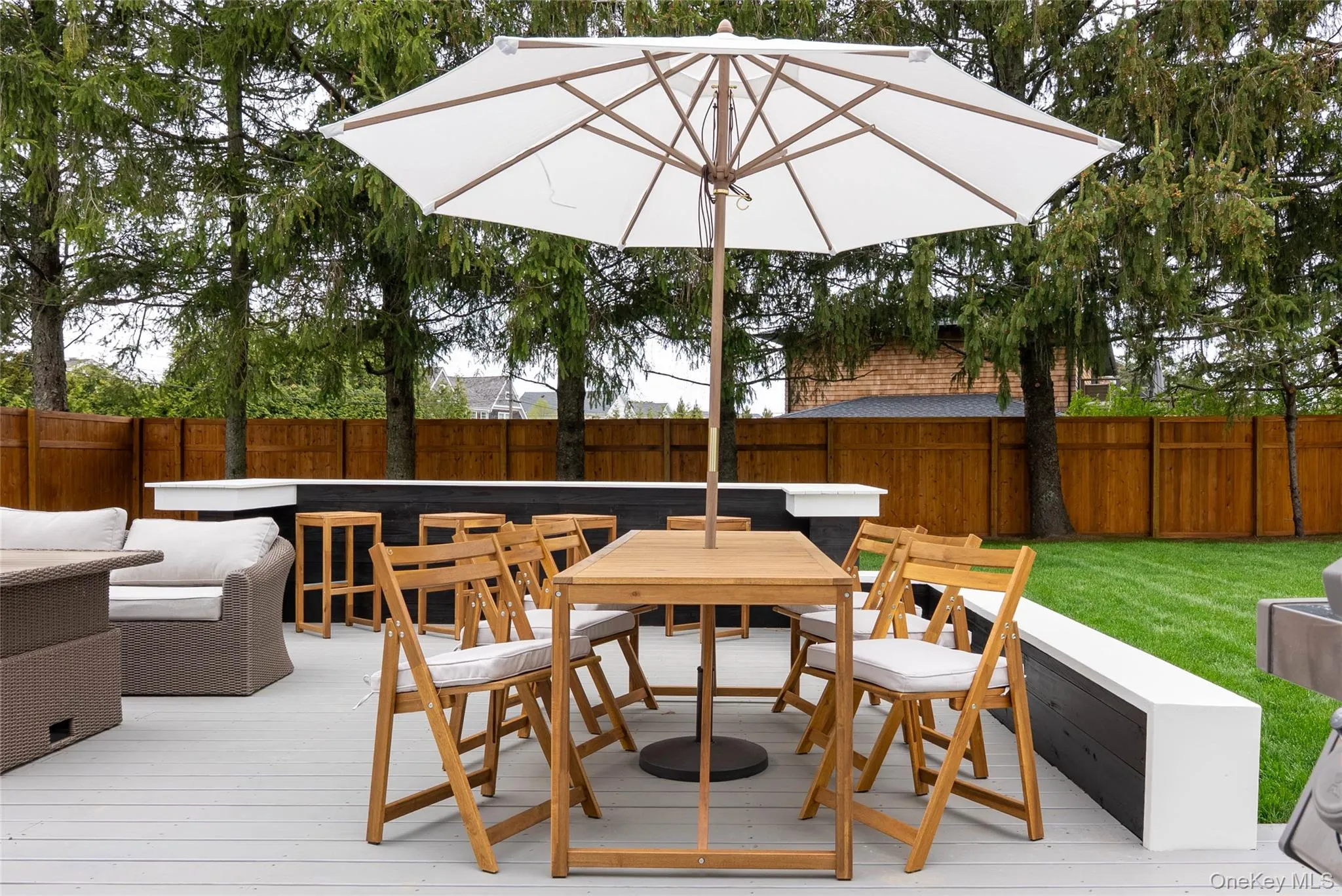 Wooden deck with a fenced backyard and outdoor dining area Wooden deck with a fenced backyard and outdoor dining area