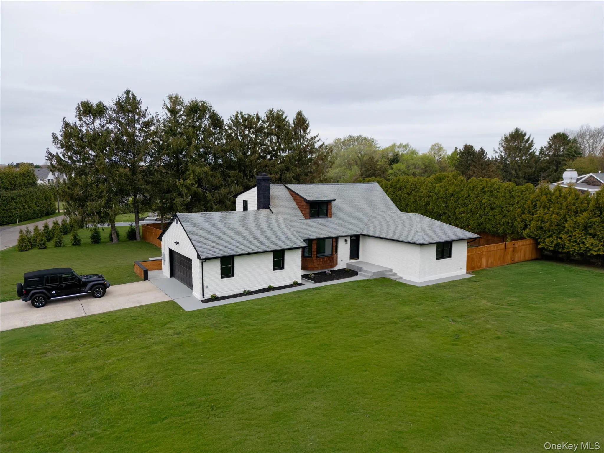 View of front of home with concrete driveway, a chimney, and roof with shingles View of front of home with concrete driveway, a chimney, and roof with shingles