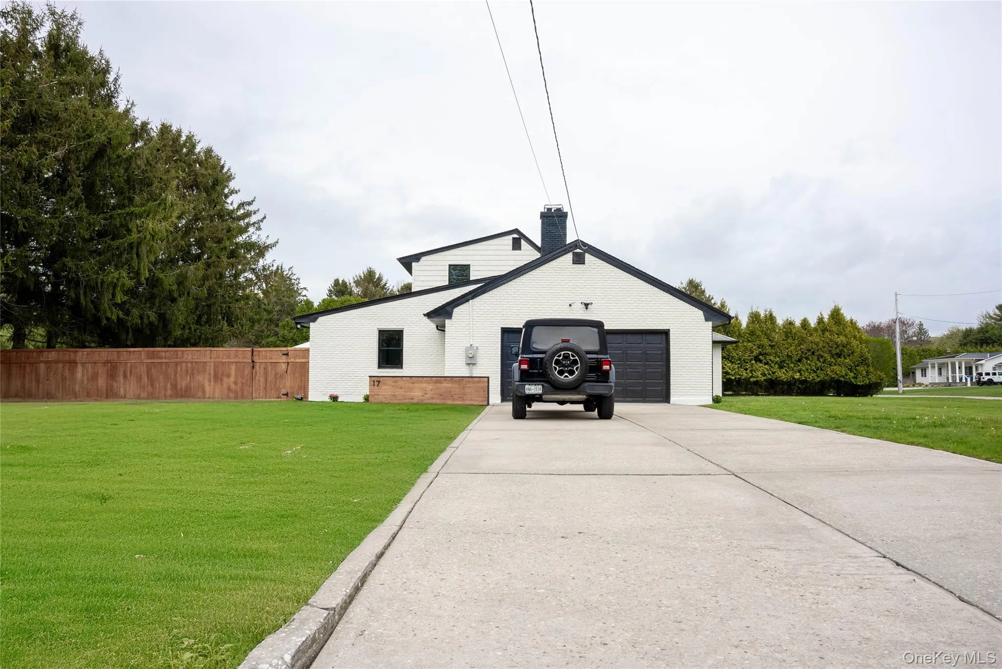 View of front facade with a chimney, concrete driveway, and brick siding View of front facade with a chimney, concrete driveway, and brick siding
