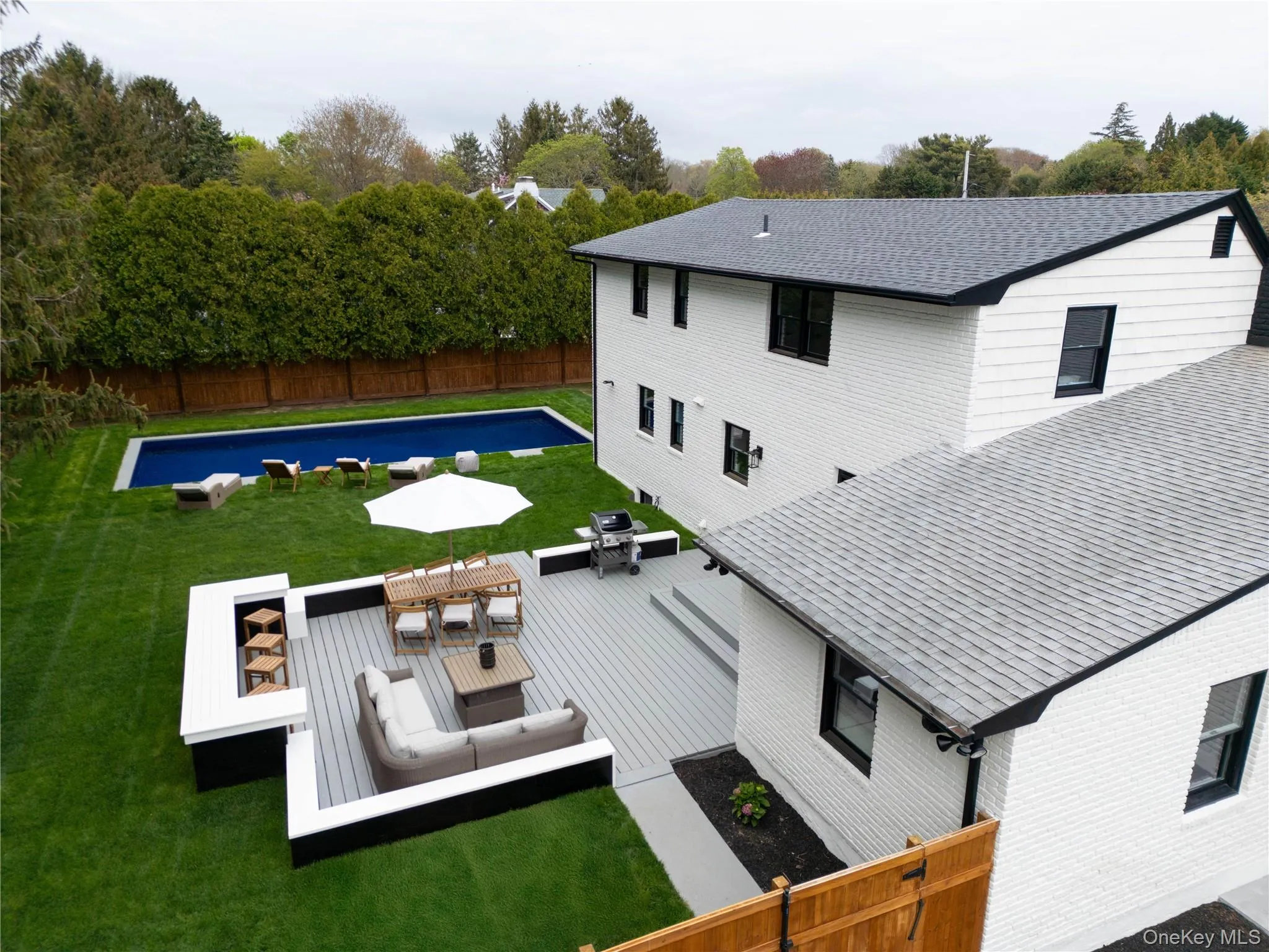 Back of property featuring a fenced backyard, a patio, outdoor dining space, outdoor lounge area, and view of scattered trees Back of property featuring a fenced backyard, a patio, outdoor dining space, outdoor lounge area, and view of scattered trees