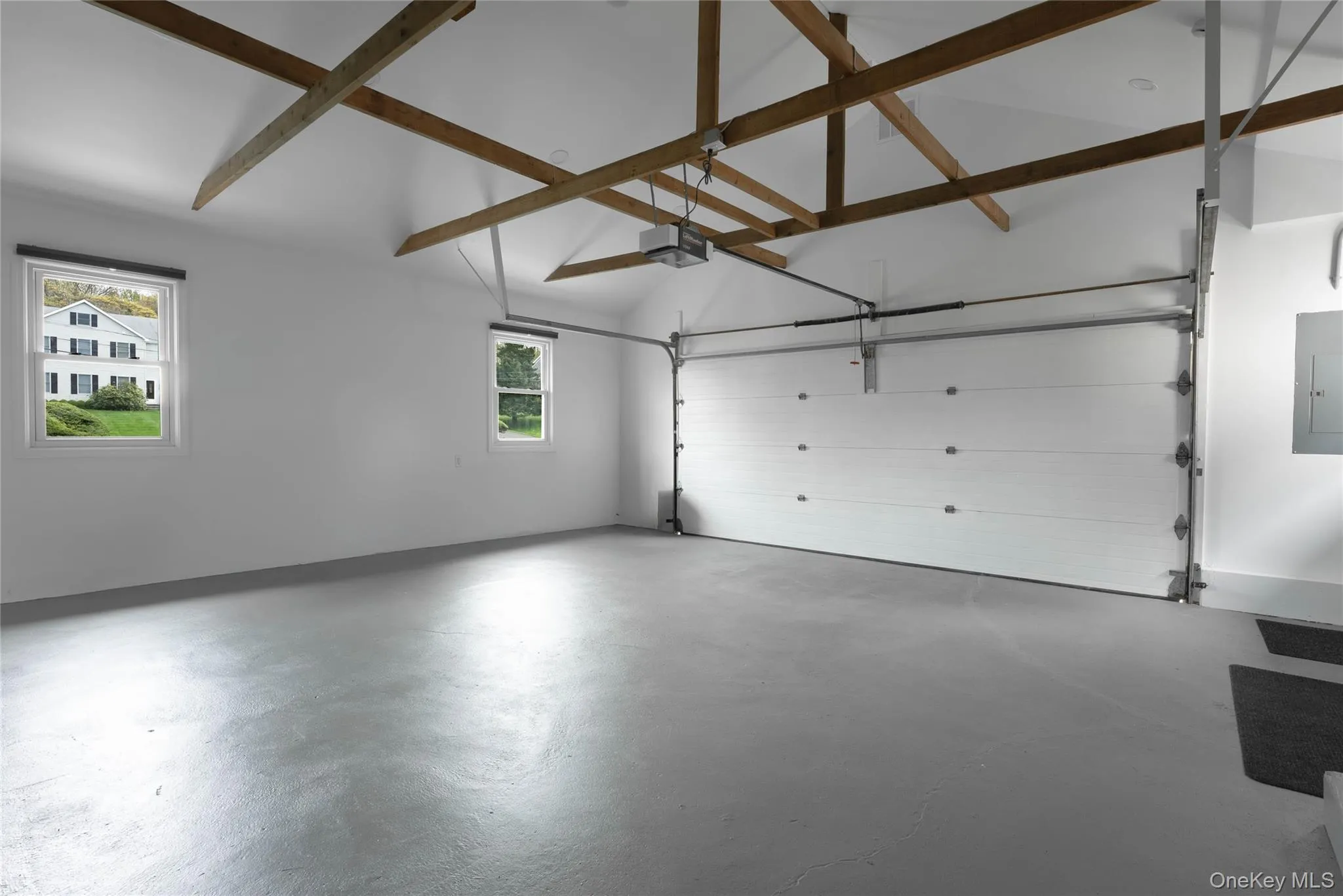 Garage featuring electric panel and a garage door opener Garage featuring electric panel and a garage door opener