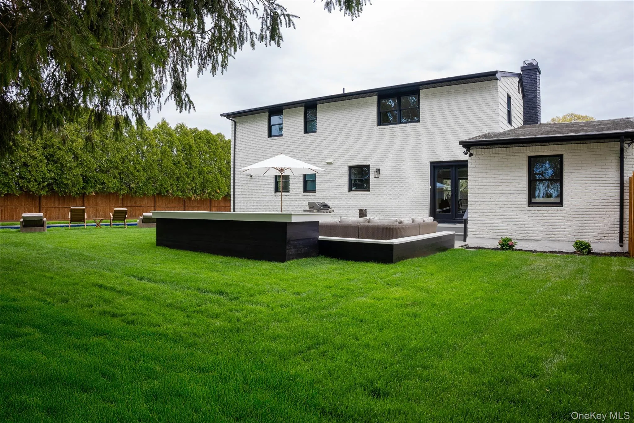 Back of house featuring an outdoor living space, a patio area, brick siding, and a chimney Back of house featuring an outdoor living space, a patio area, brick siding, and a chimney