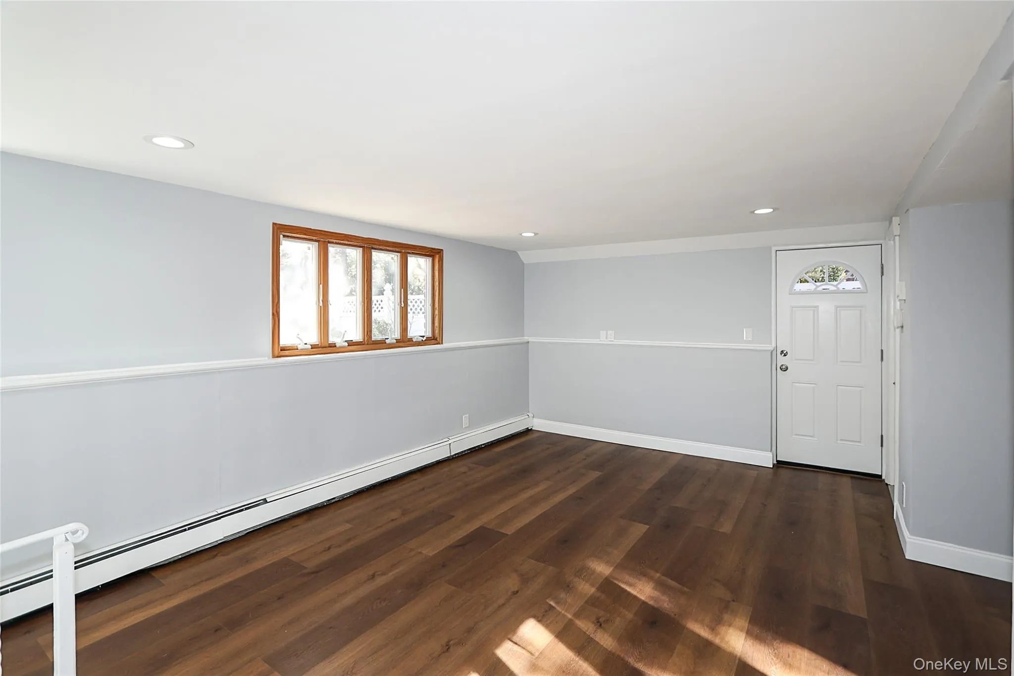 Unfurnished room featuring a baseboard heating unit, dark wood finished floors, and recessed lighting Unfurnished room featuring a baseboard heating unit, dark wood finished floors, and recessed lighting