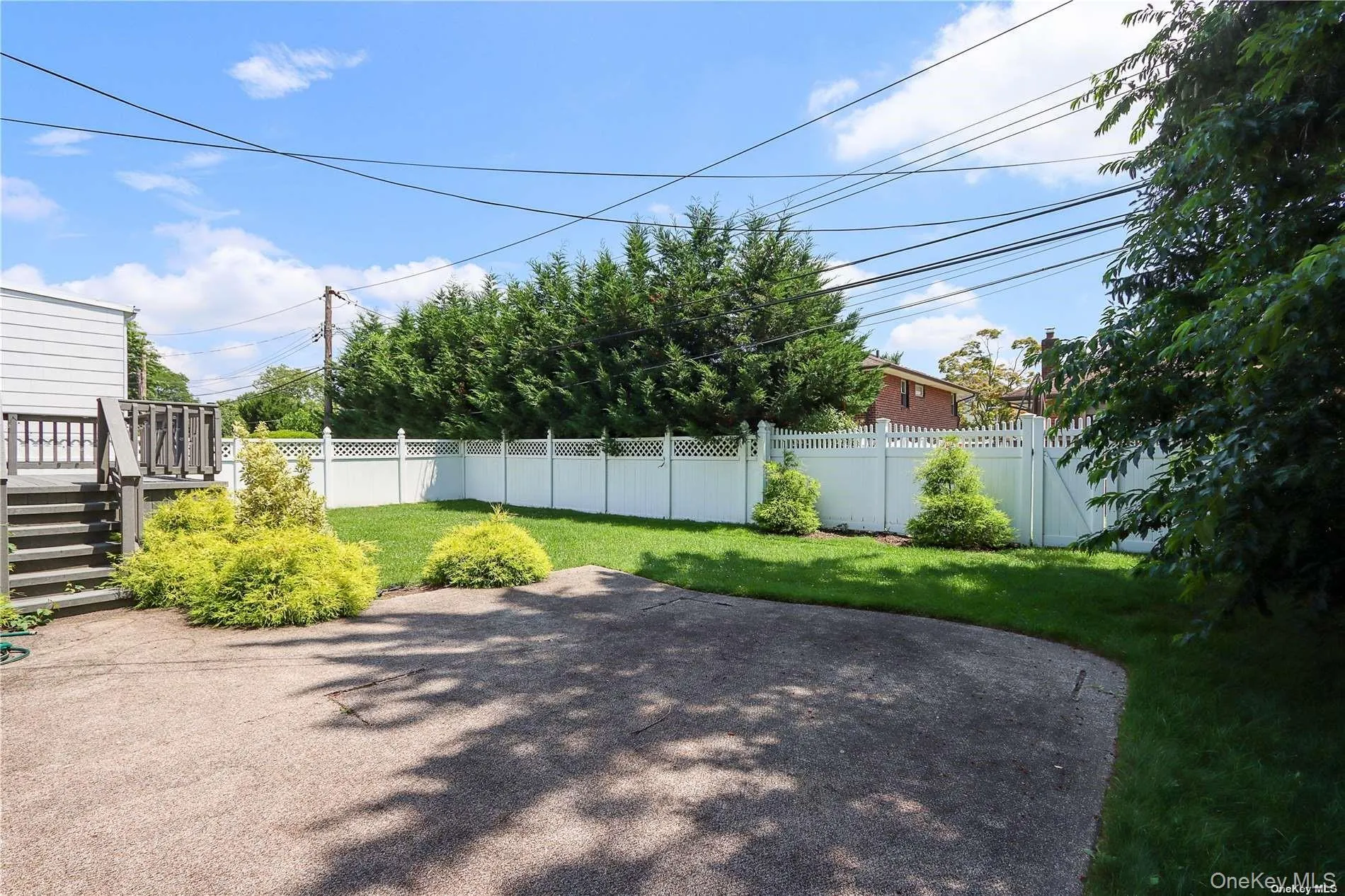 Fenced backyard featuring a patio area and a deck Fenced backyard featuring a patio area and a deck