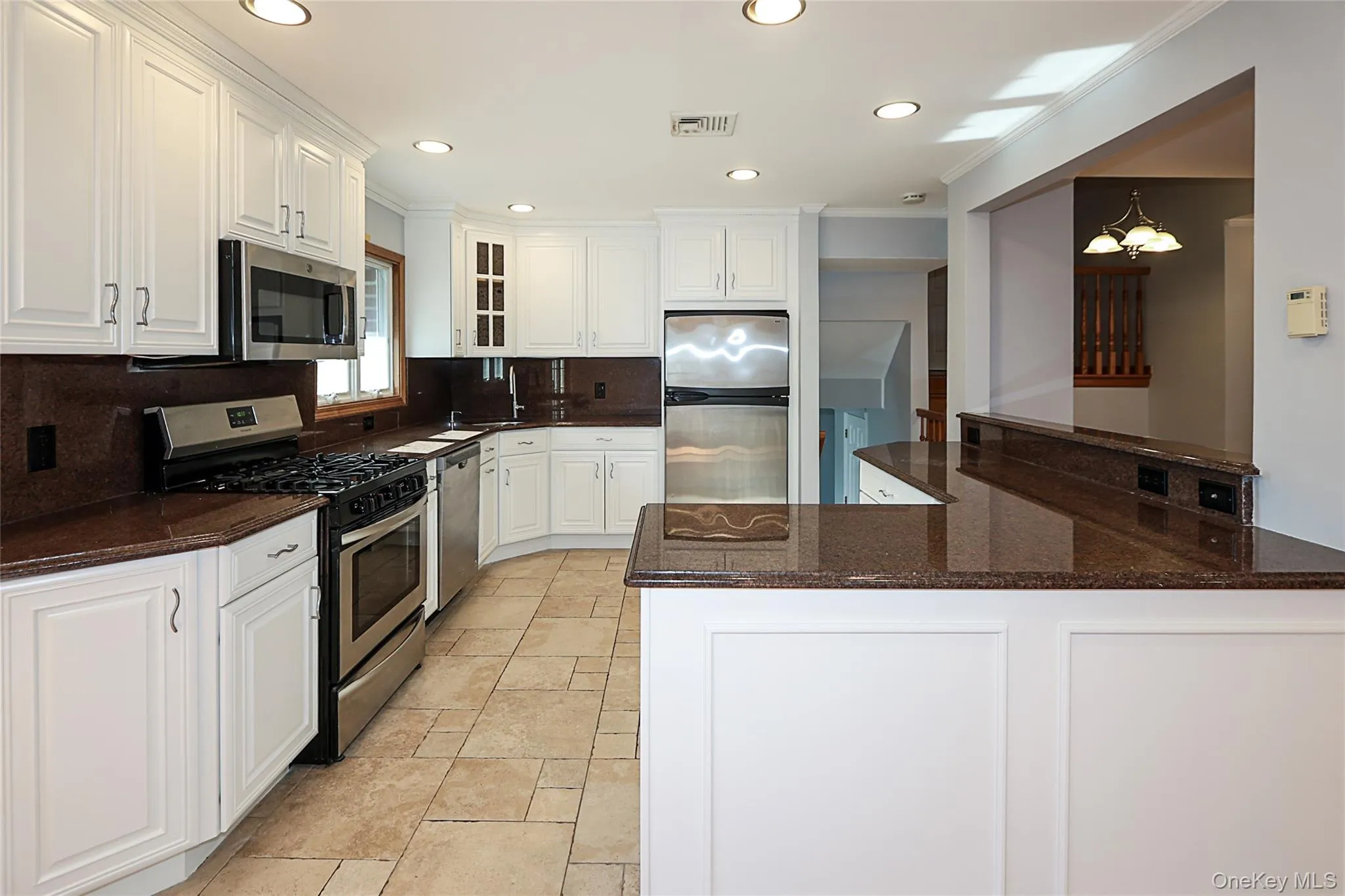 Kitchen featuring appliances with stainless steel finishes, dark stone counters, white cabinetry, tasteful backsplash, and recessed lighting Kitchen featuring appliances with stainless steel finishes, dark stone counters, white cabinetry, tasteful backsplash, and recessed lighting
