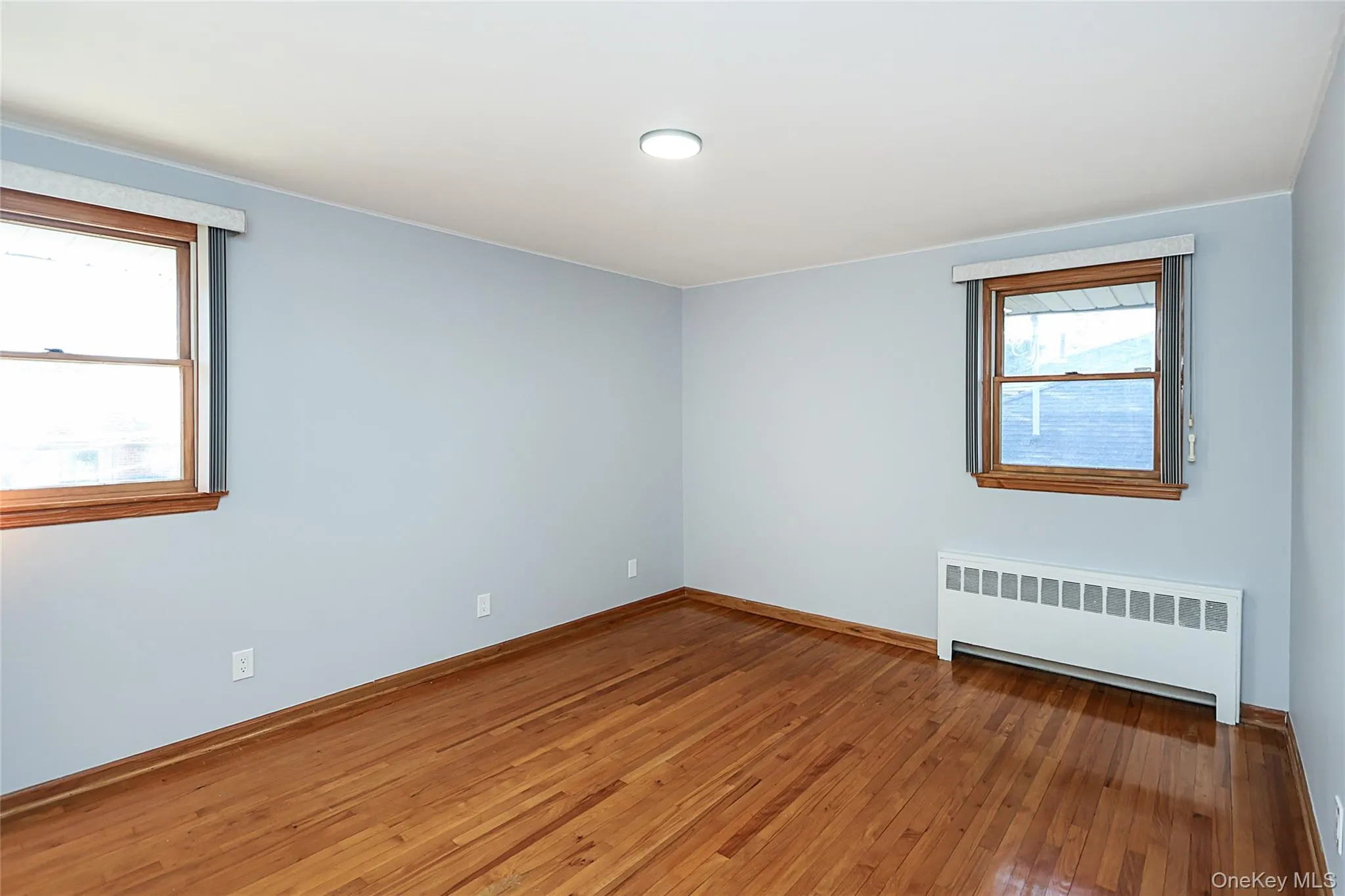 Empty room with radiator and hardwood / wood-style flooring Empty room with radiator and hardwood / wood-style flooring