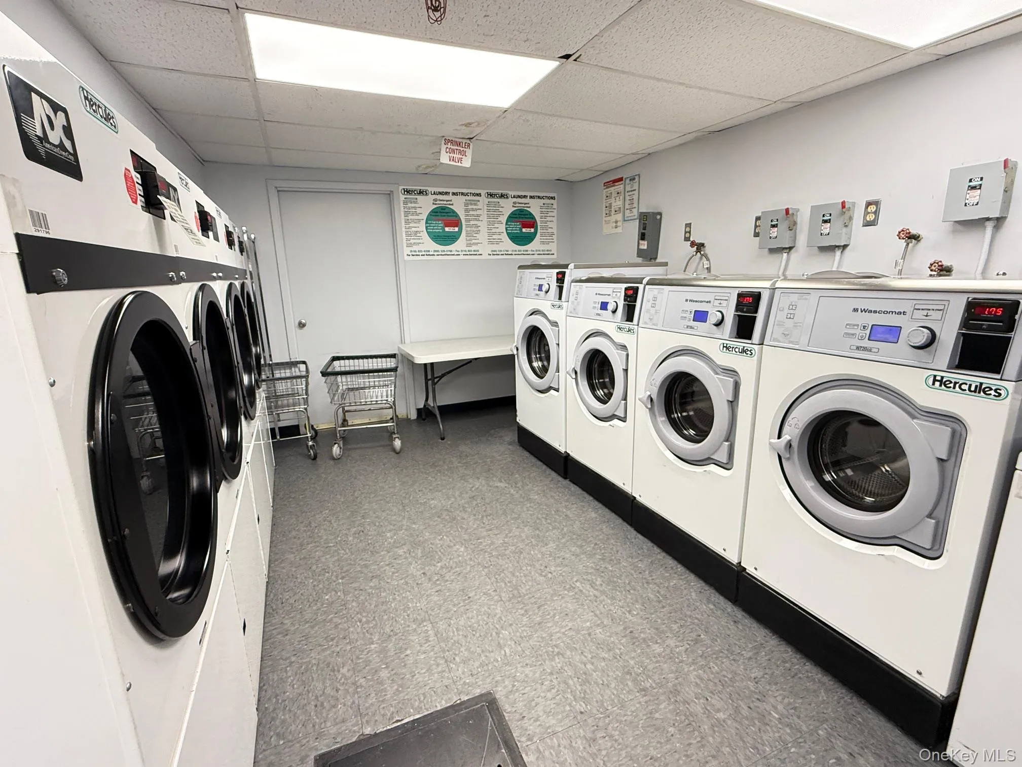 Community laundry room featuring a paneled ceiling and separate washer and dryer Community laundry room featuring a paneled ceiling and separate washer and dryer