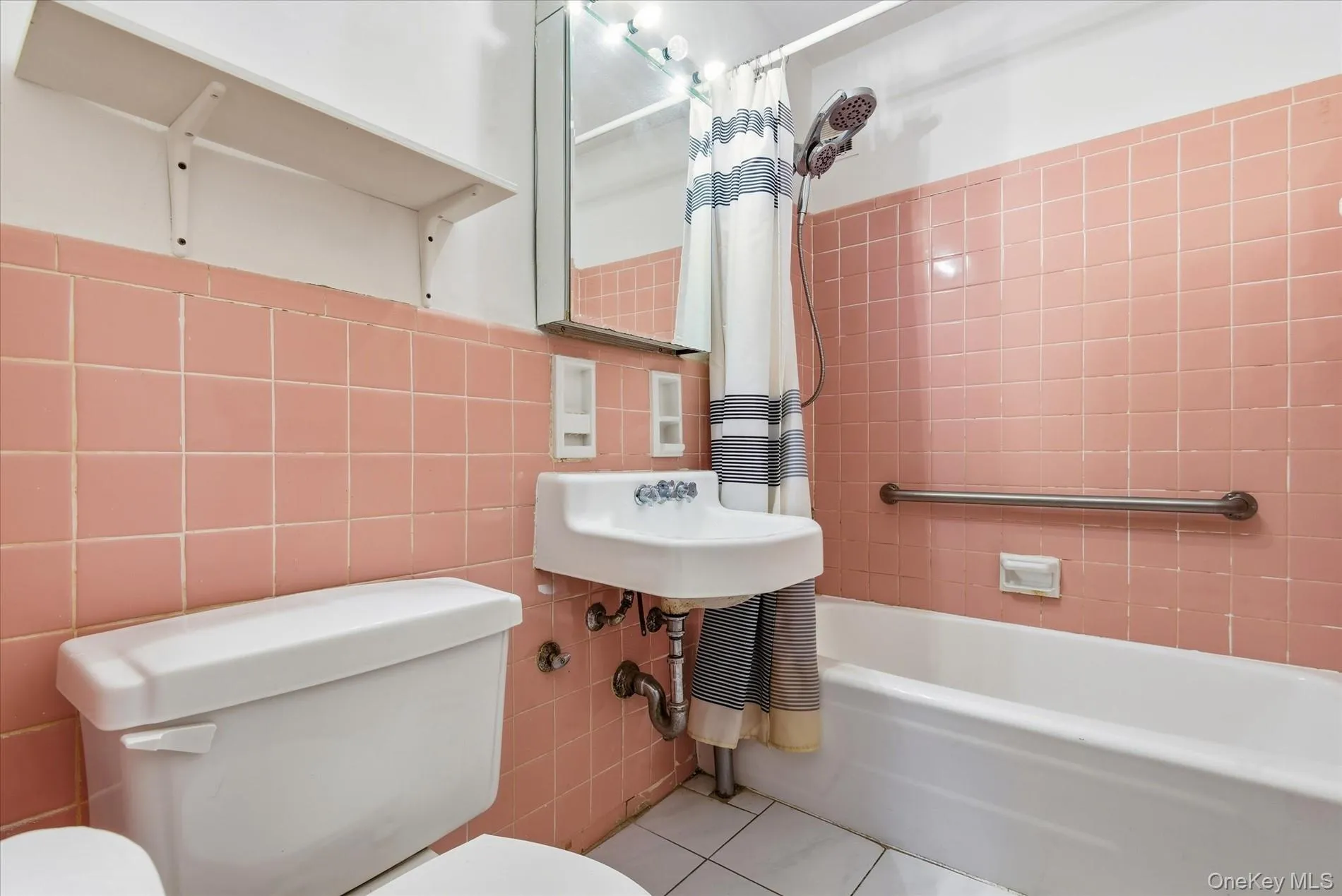 Full bathroom featuring shower / bath combination with curtain, tile walls, tile patterned flooring, and backsplash Full bathroom featuring shower / bath combination with curtain, tile walls, tile patterned flooring, and backsplash
