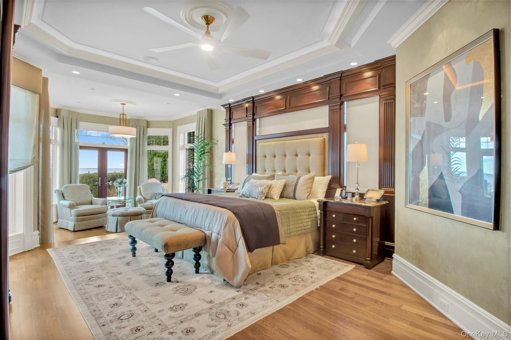 Bedroom featuring crown molding, a raised ceiling, light wood-style flooring, french doors, and recessed lighting Bedroom featuring crown molding, a raised ceiling, light wood-style flooring, french doors, and recessed lighting