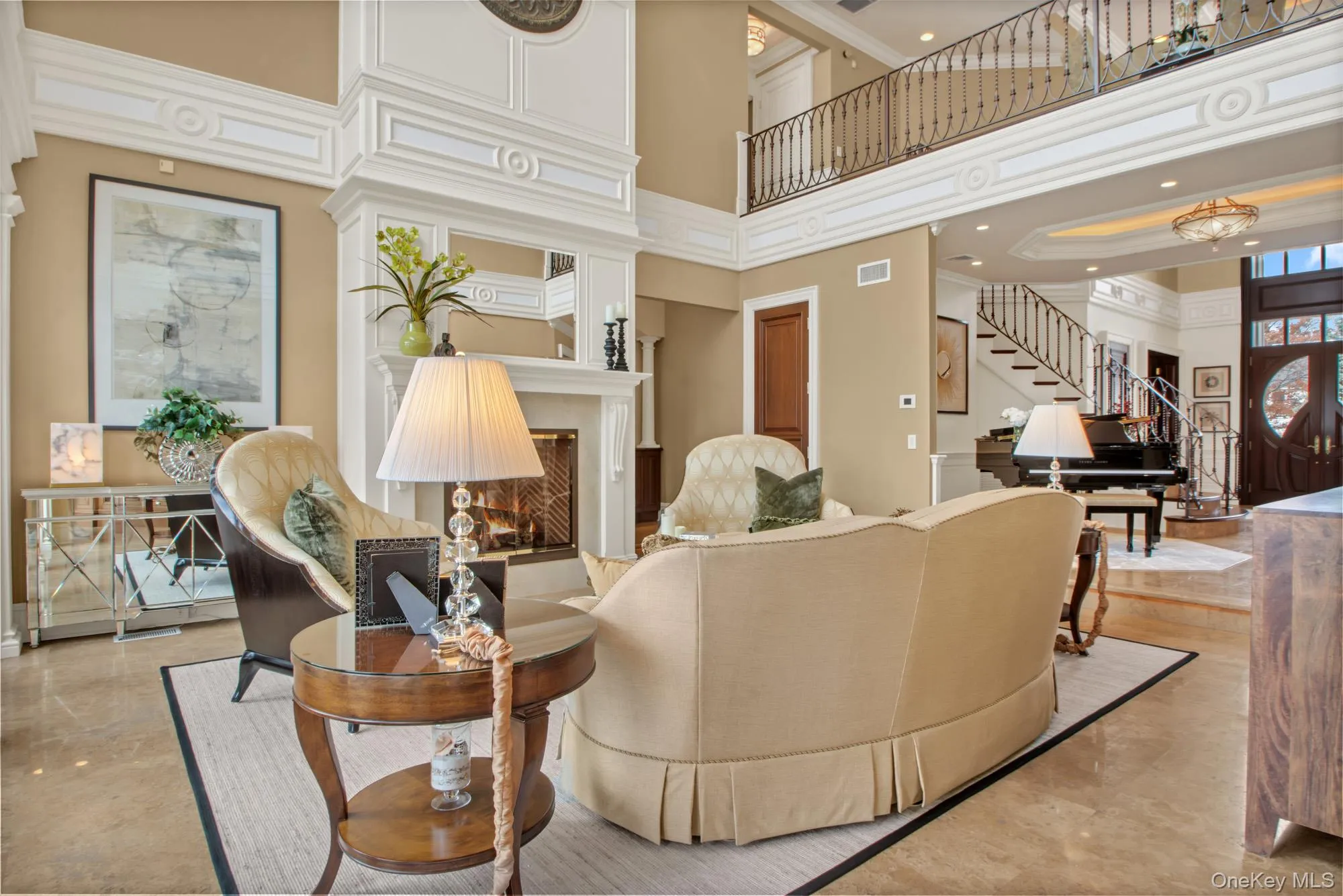 Living area with a towering ceiling, a lit fireplace, stairs, and crown molding Living area with a towering ceiling, a lit fireplace, stairs, and crown molding