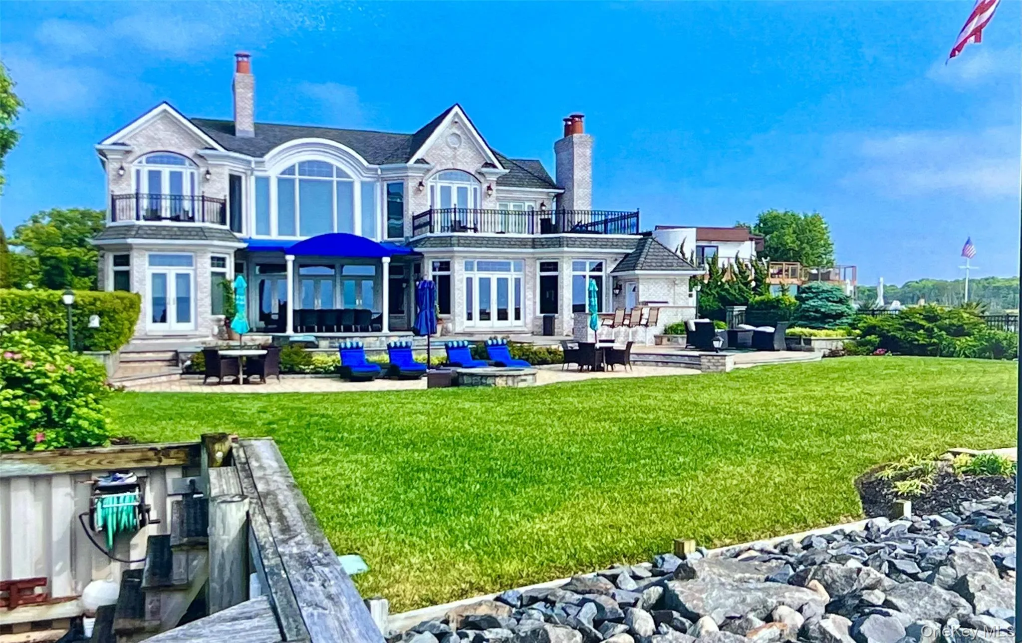Back of property with a patio, a chimney, a balcony, and french doors Back of property with a patio, a chimney, a balcony, and french doors