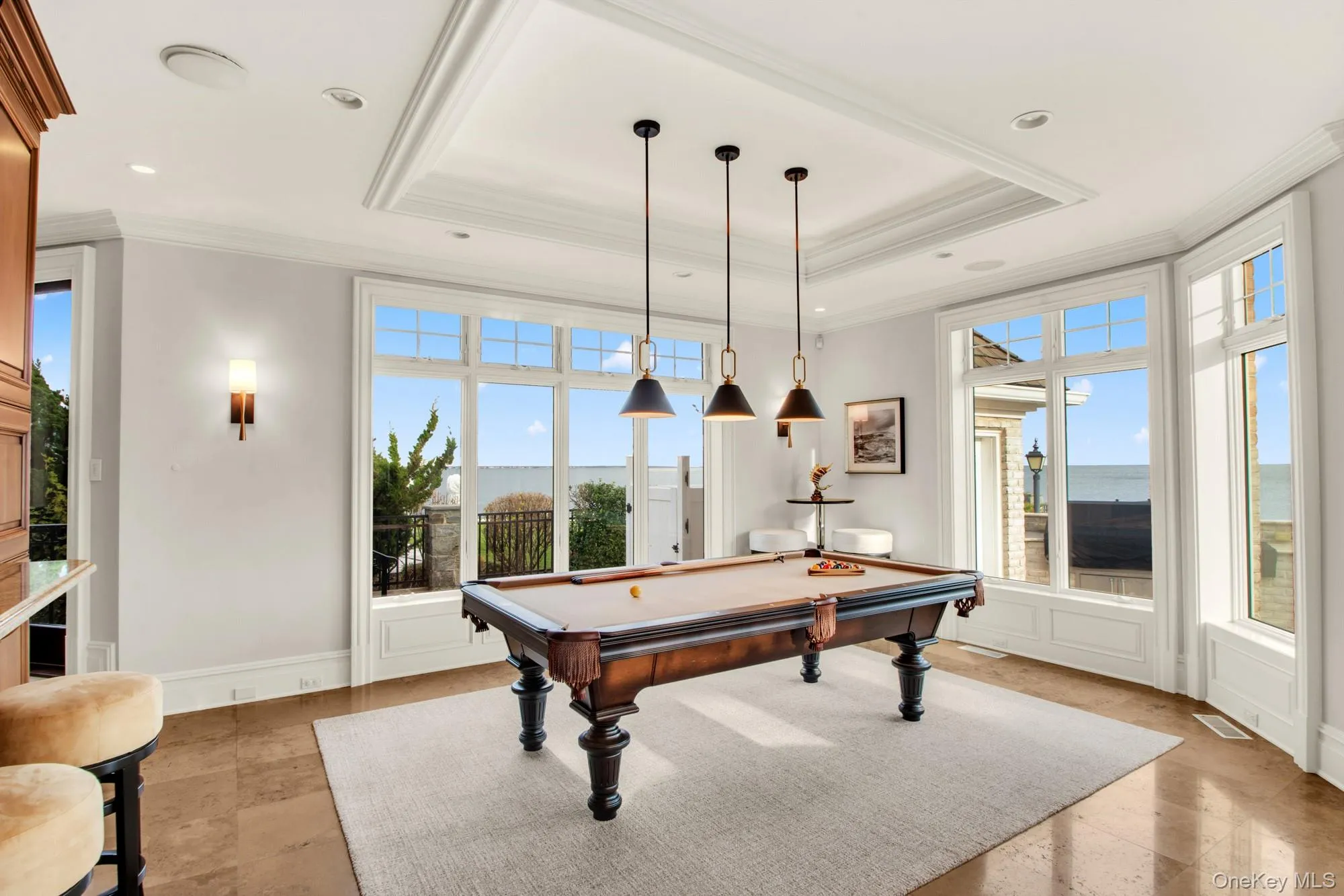 Recreation room featuring a tray ceiling, ornamental molding, billiards, and a water view Recreation room featuring a tray ceiling, ornamental molding, billiards, and a water view