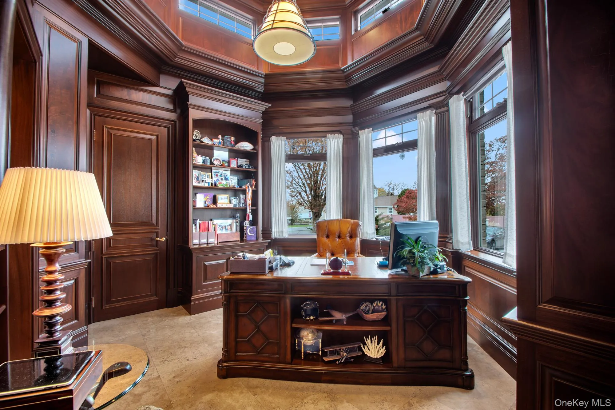 Office area featuring crown molding, built in features, a towering ceiling, and wood walls Office area featuring crown molding, built in features, a towering ceiling, and wood walls