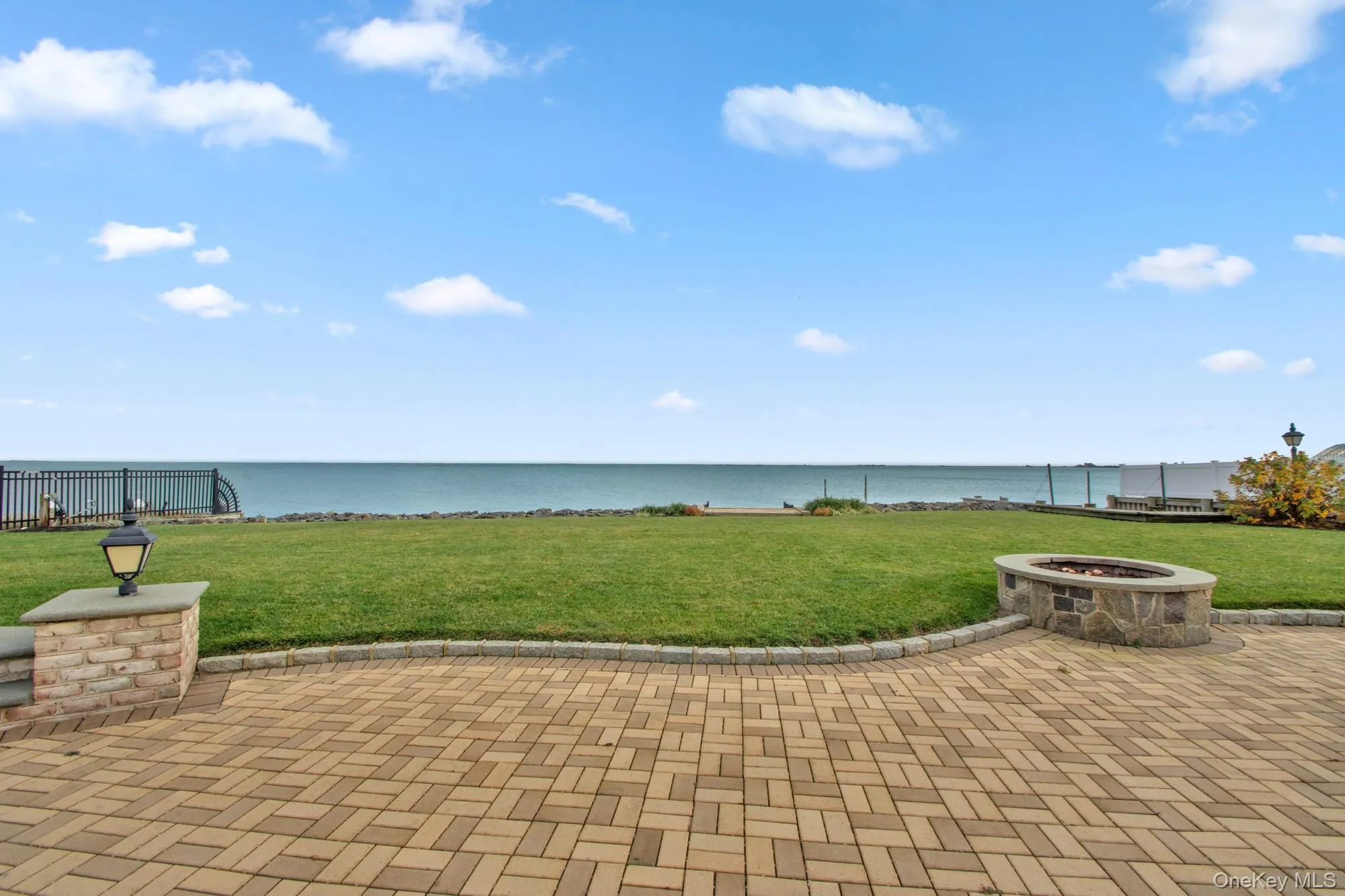 View of patio / terrace with a water view and a fire pit View of patio / terrace with a water view and a fire pit