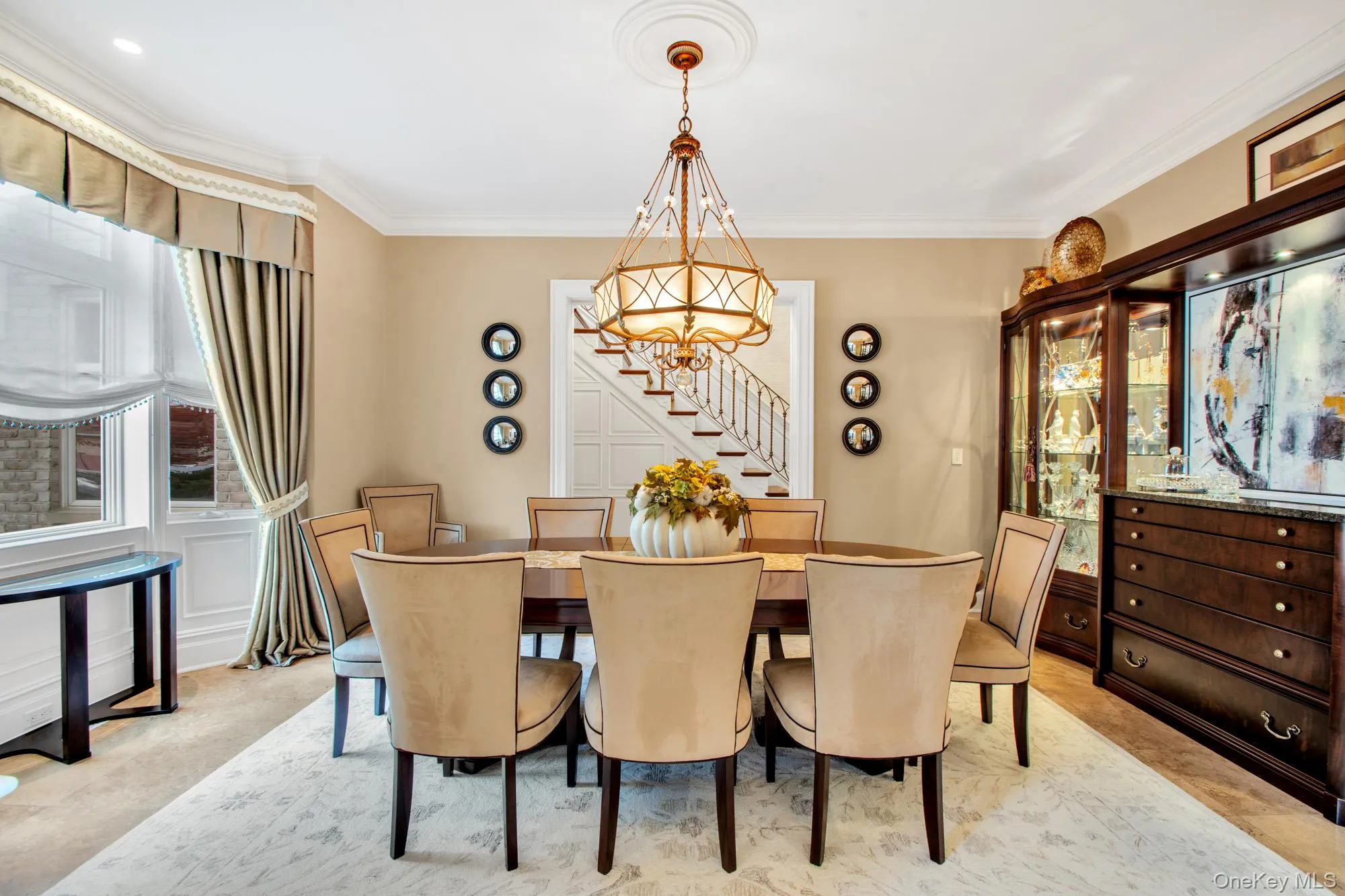 Dining area featuring ornamental molding, a chandelier, light colored carpet, and stairway Dining area featuring ornamental molding, a chandelier, light colored carpet, and stairway