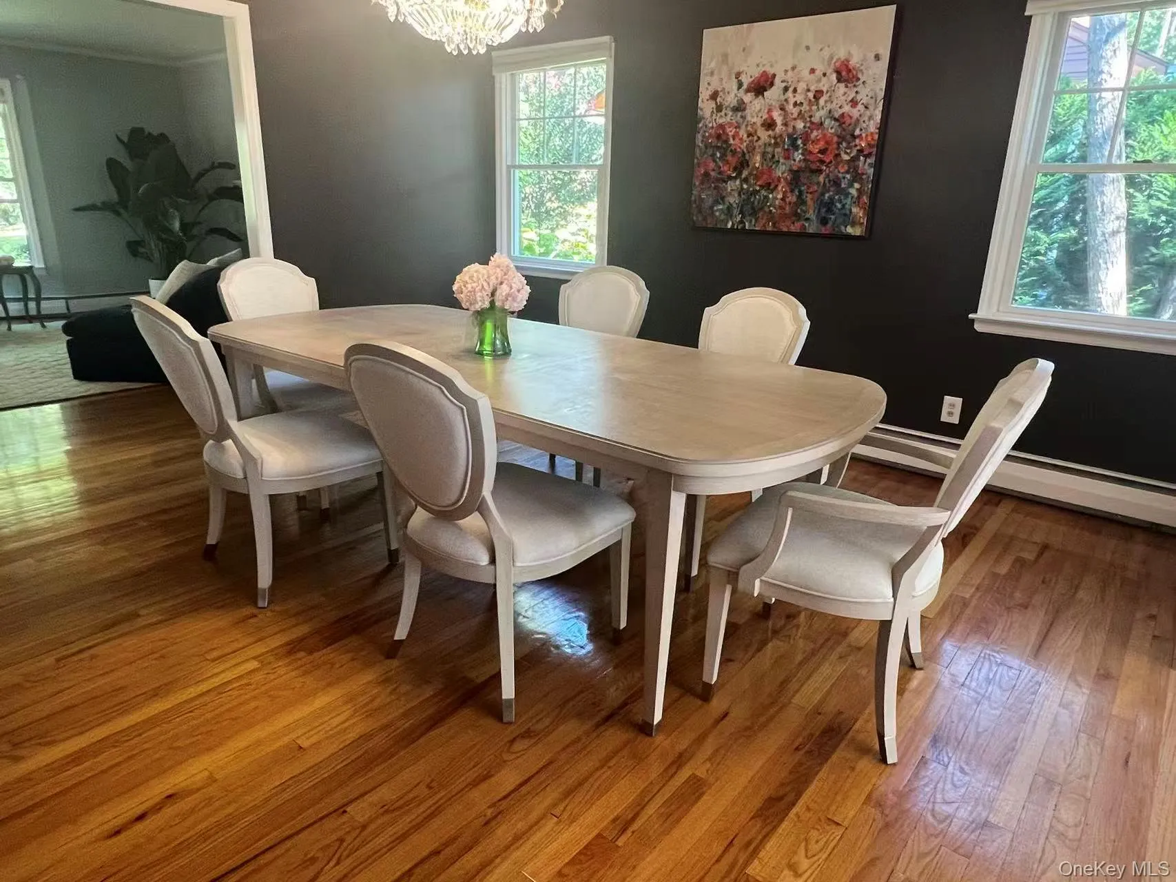 Dining area with wood-type flooring, a chandelier, and a baseboard radiator Dining area with wood-type flooring, a chandelier, and a baseboard radiator