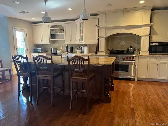 Kitchen featuring pendant lighting, designer stove, recessed lighting, light stone counters, and backsplash Kitchen featuring pendant lighting, designer stove, recessed lighting, light stone counters, and backsplash