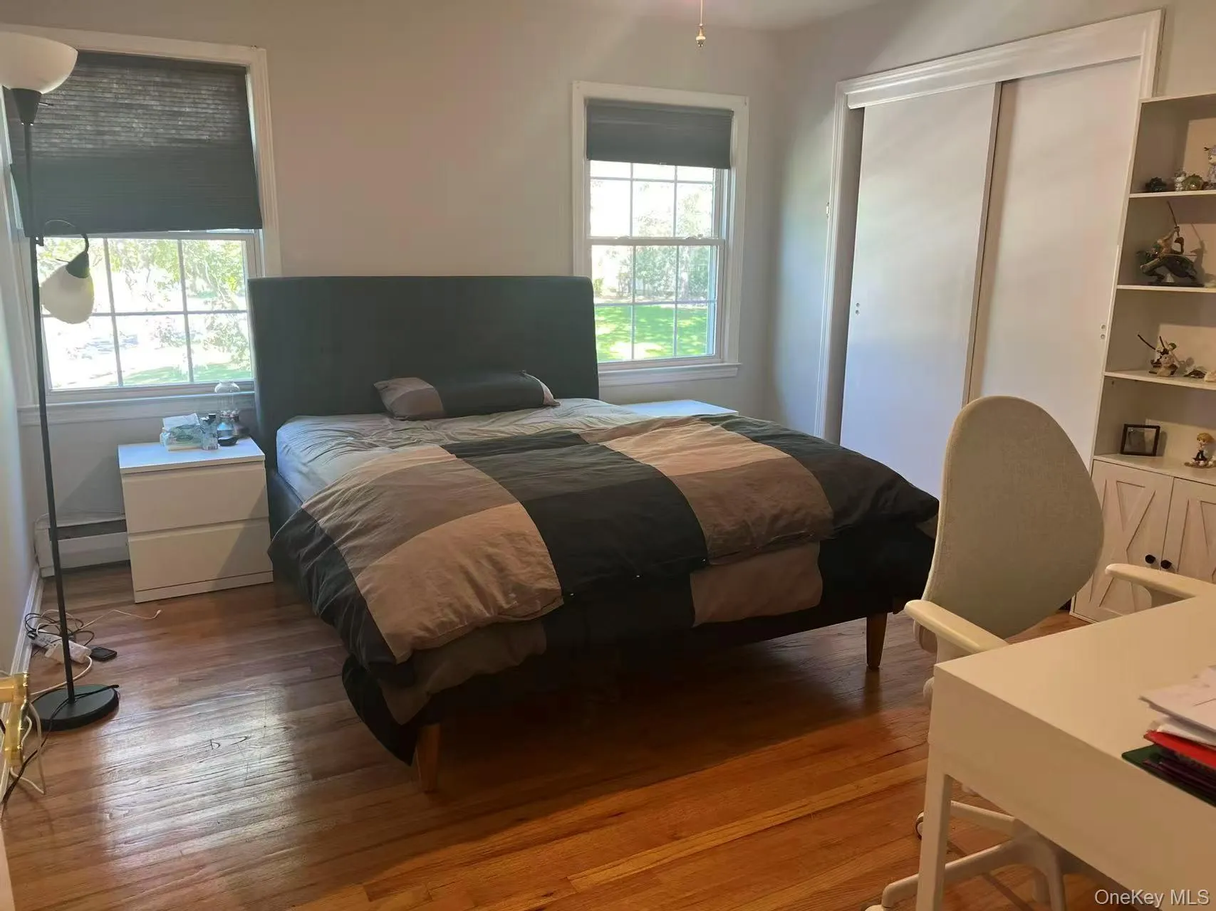 Bedroom featuring light wood-type flooring, a baseboard radiator, and a closet Bedroom featuring light wood-type flooring, a baseboard radiator, and a closet