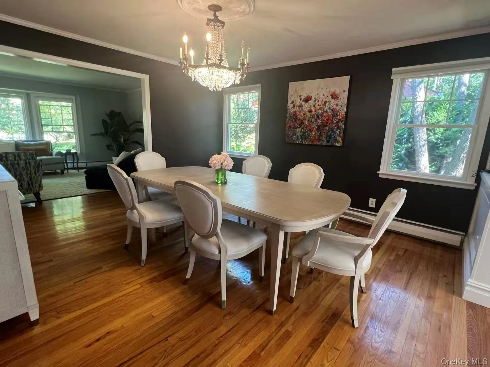 Dining space with ornamental molding, hardwood / wood-style flooring, a chandelier, a baseboard radiator, and baseboard heating Dining space with ornamental molding, hardwood / wood-style flooring, a chandelier, a baseboard radiator, and baseboard heating