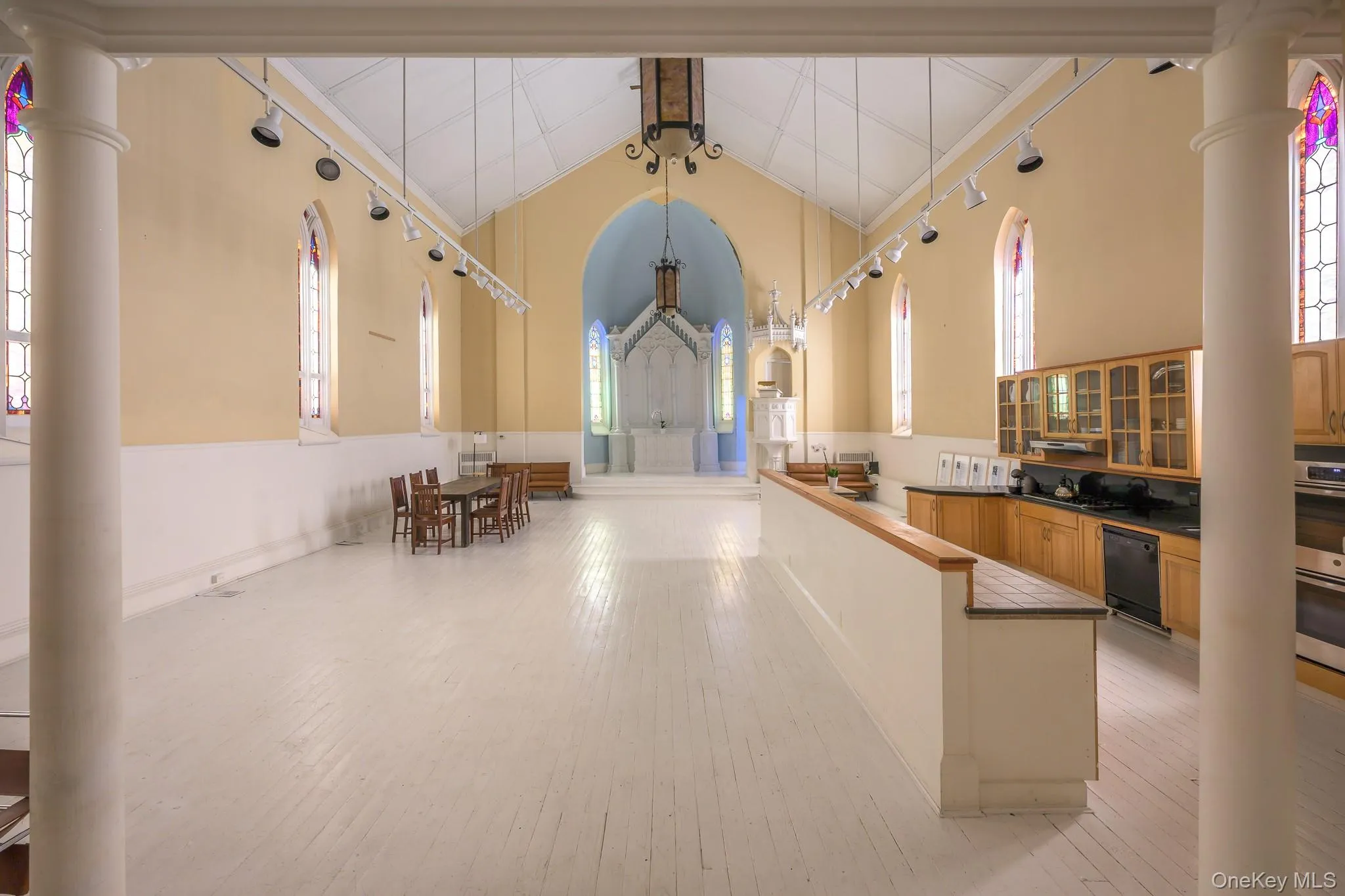 Kitchen with dark countertops, a peninsula, decorative columns, glass insert cabinets, and plenty of natural light Kitchen with dark countertops, a peninsula, decorative columns, glass insert cabinets, and plenty of natural light