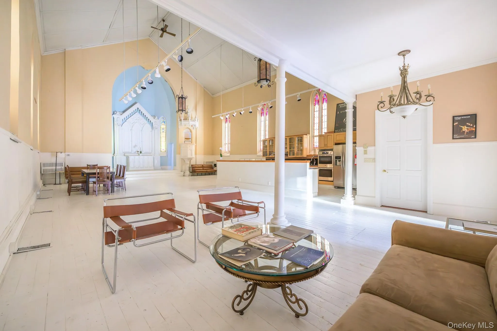 Living room with light wood-style flooring, high vaulted ceiling, and crown molding Living room with light wood-style flooring, high vaulted ceiling, and crown molding