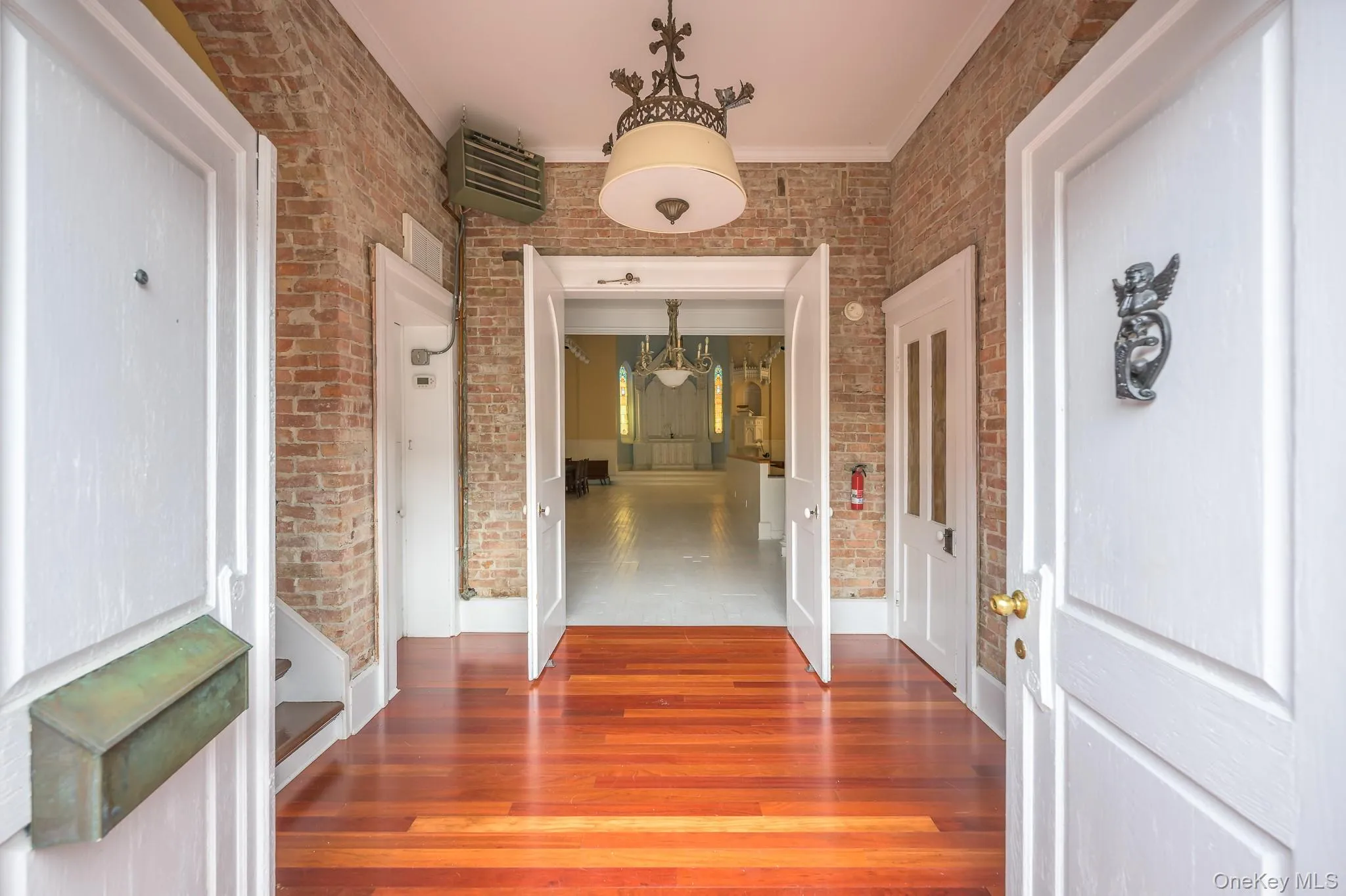 Hall featuring wood finished floors, a heating unit, and crown molding Hall featuring wood finished floors, a heating unit, and crown molding