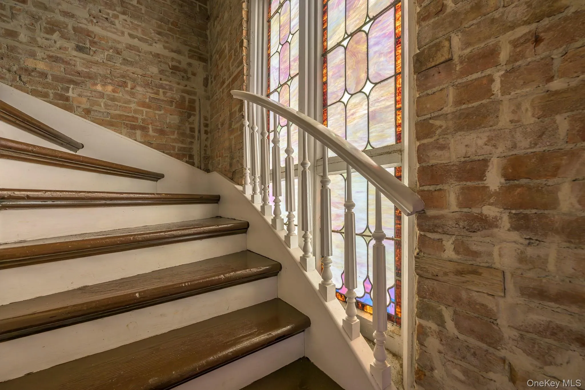 Stairway featuring brick wall Stairway featuring brick wall