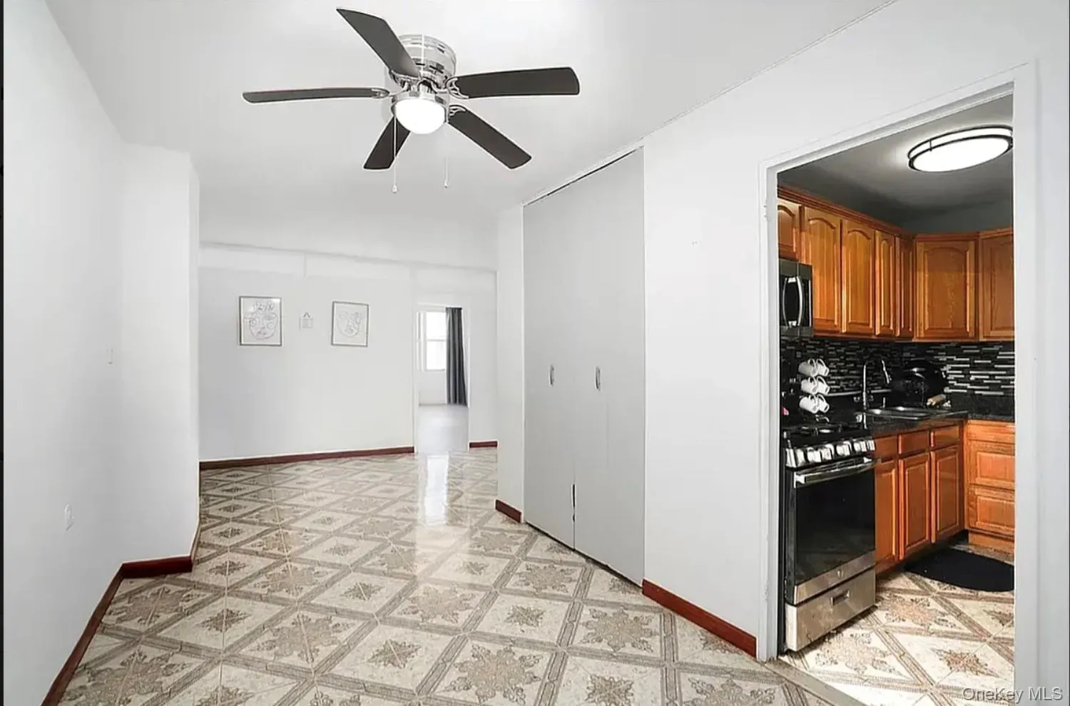 Kitchen with decorative backsplash, stainless steel appliances, brown cabinetry, a ceiling fan, and dark stone countertops Kitchen with decorative backsplash, stainless steel appliances, brown cabinetry, a ceiling fan, and dark stone countertops