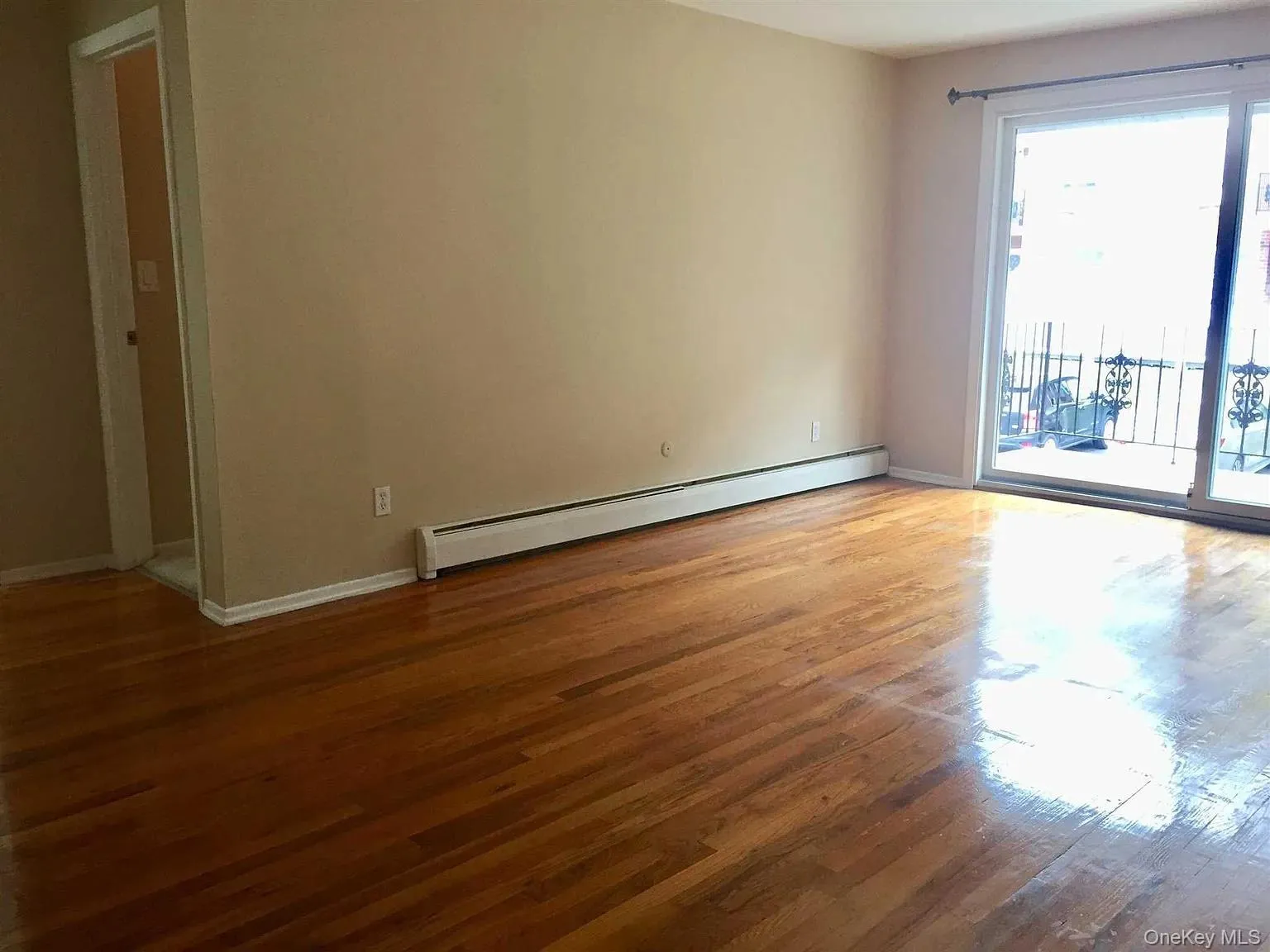 Spare room with light wood finished floors and a baseboard heating unit Spare room with light wood finished floors and a baseboard heating unit