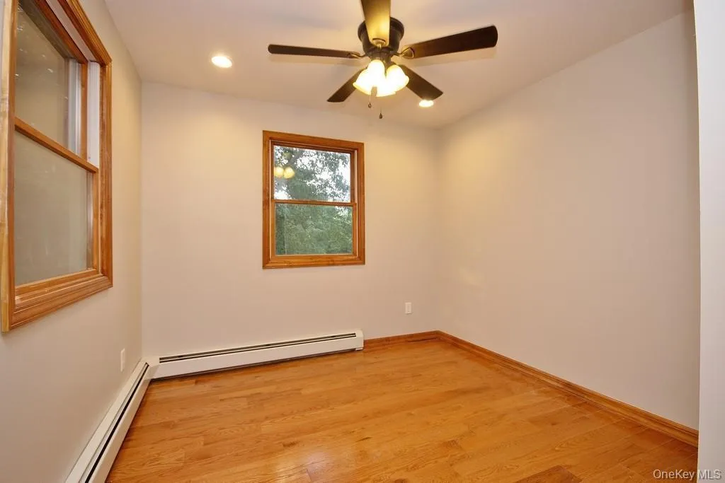Unfurnished room with light wood-type flooring, baseboard heating, recessed lighting, and ceiling fan Unfurnished room with light wood-type flooring, baseboard heating, recessed lighting, and ceiling fan