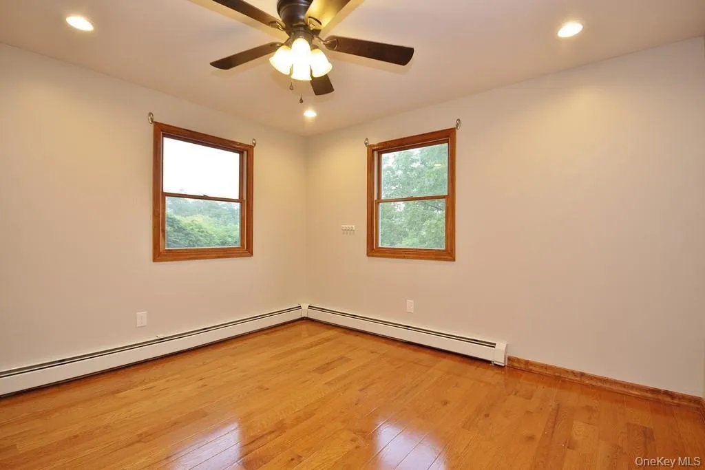 Unfurnished room with recessed lighting, light wood finished floors, baseboard heating, and ceiling fan Unfurnished room with recessed lighting, light wood finished floors, baseboard heating, and ceiling fan