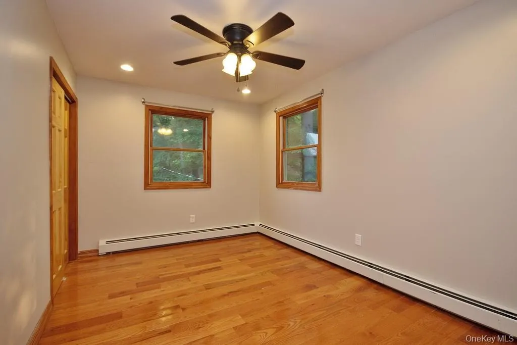 Unfurnished bedroom with a baseboard heating unit, light wood-type flooring, recessed lighting, ceiling fan, and a closet Unfurnished bedroom with a baseboard heating unit, light wood-type flooring, recessed lighting, ceiling fan, and a closet