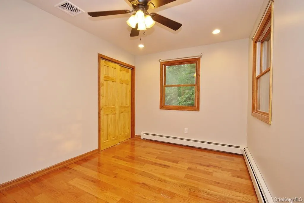 Unfurnished bedroom featuring light wood-style floors, baseboard heating, ceiling fan, recessed lighting, and a closet Unfurnished bedroom featuring light wood-style floors, baseboard heating, ceiling fan, recessed lighting, and a closet
