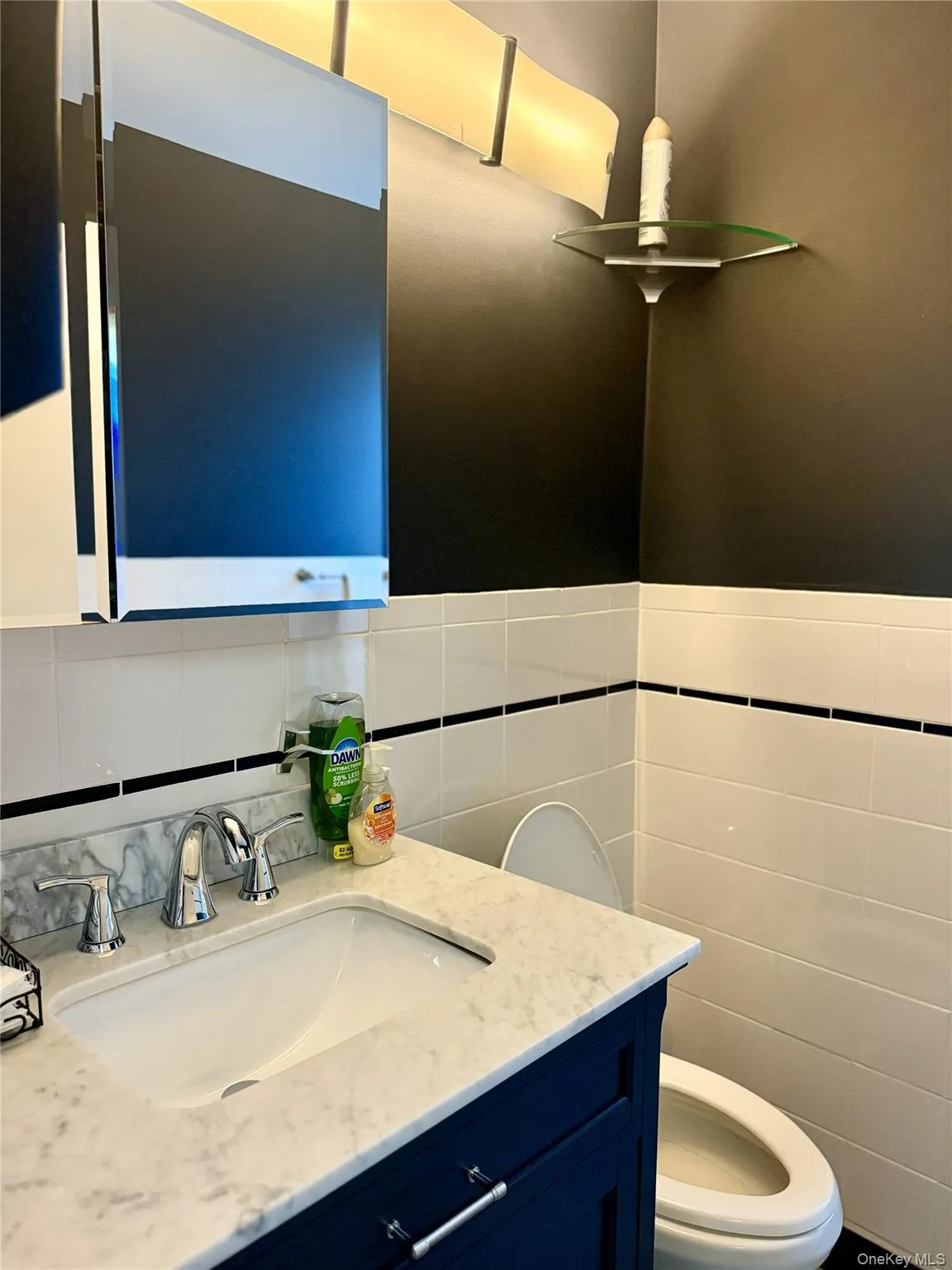 Bathroom featuring vanity and tile walls Bathroom featuring vanity and tile walls