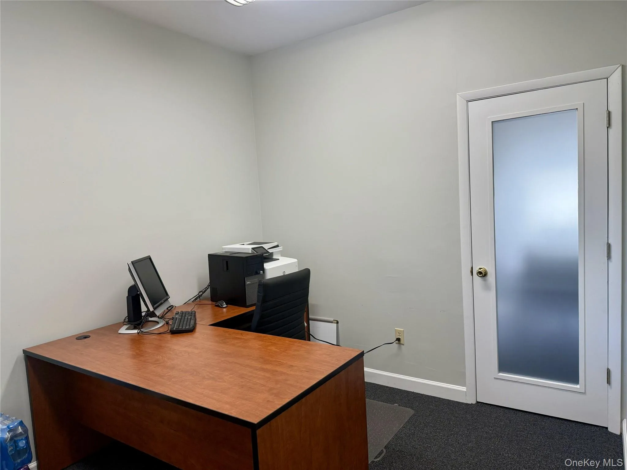 Office area featuring baseboards and dark colored carpet Office area featuring baseboards and dark colored carpet