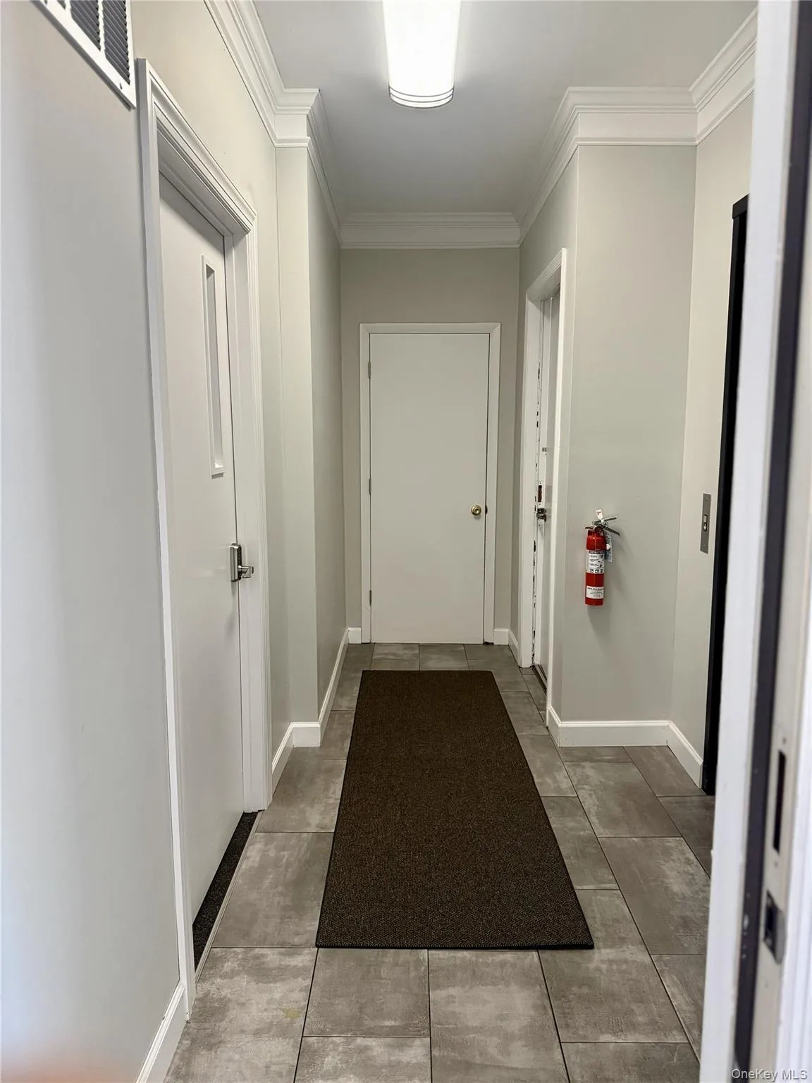 Corridor featuring ornamental molding and concrete floors Corridor featuring ornamental molding and concrete floors