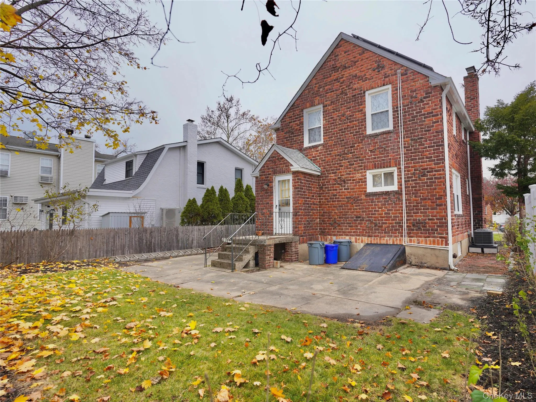Rear view of house with a patio, brick siding, and a chimney Rear view of house with a patio, brick siding, and a chimney